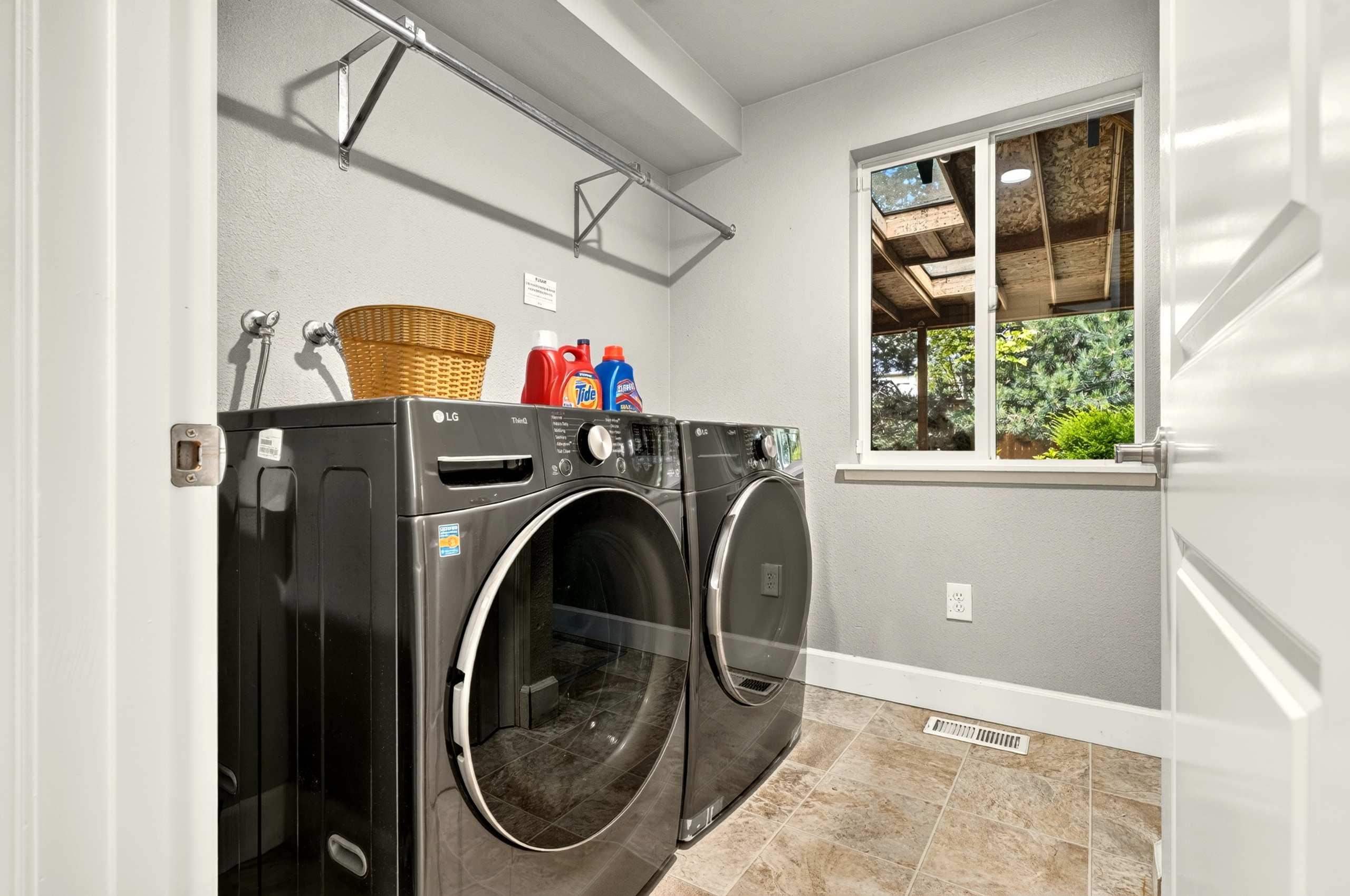 Bright laundry room with modern washer/dryer and handy hanging rack