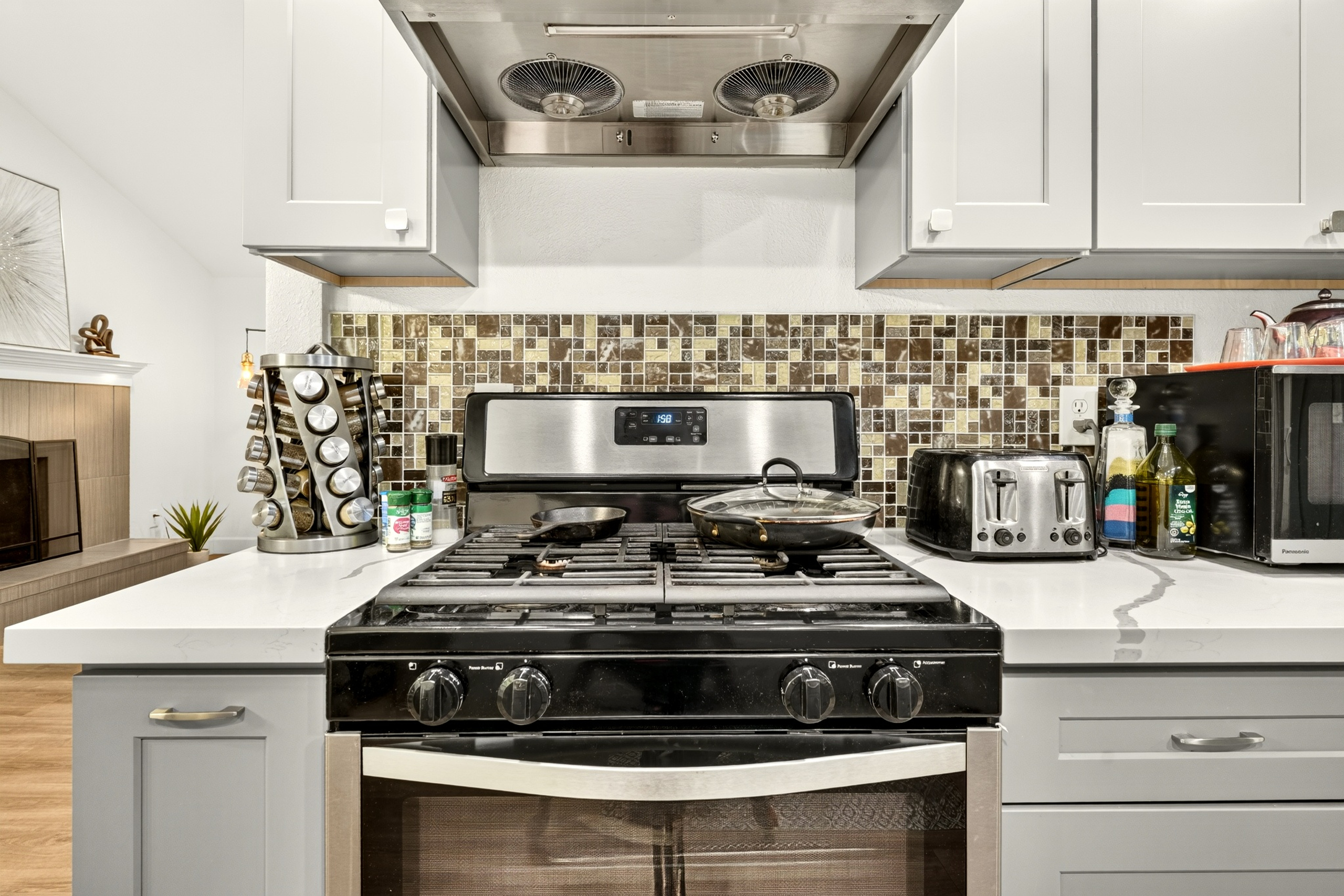 Modern kitchen with gas range, vent hood, and sleek updated finishes