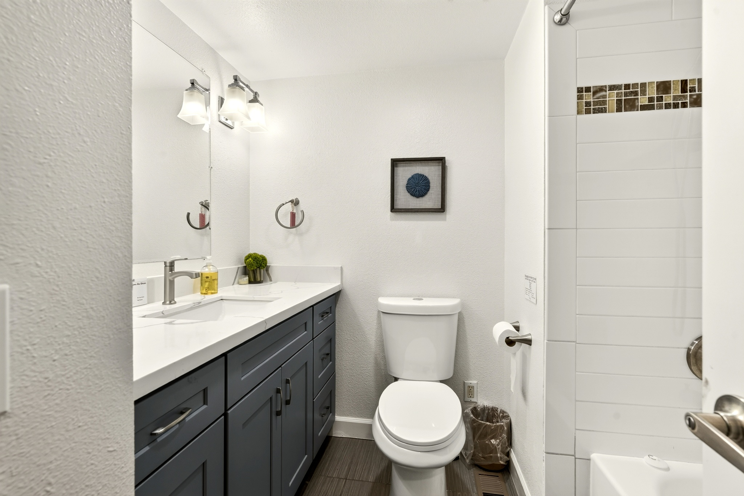 Bright modern bathroom with sleek vanity and tiled shower-tub combo