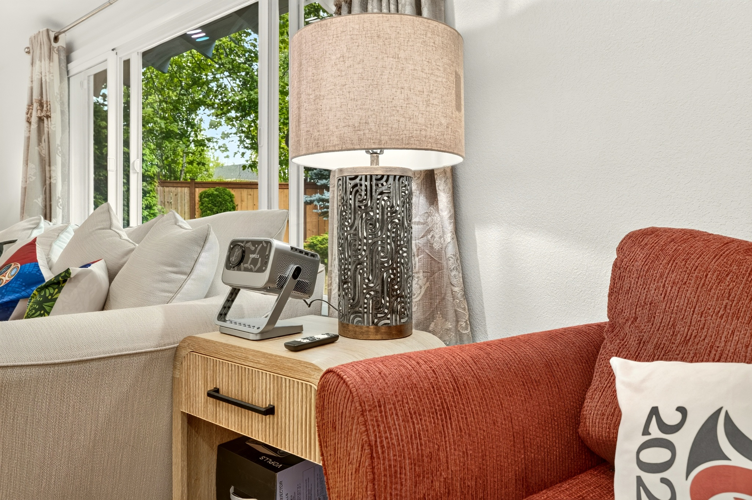 Sunny living room nook with cozy seating and large garden-view windows