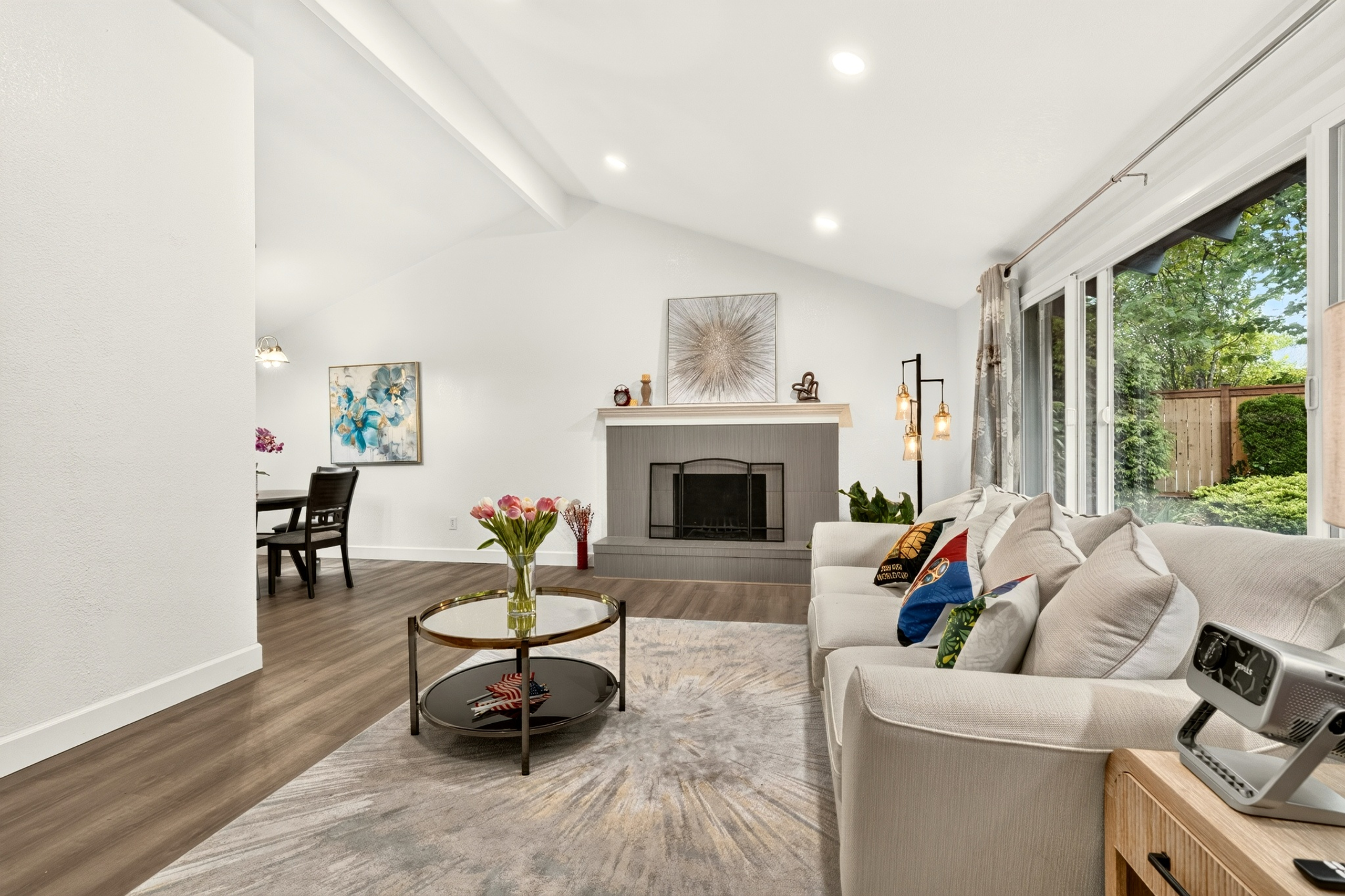 Bright vaulted living room with fireplace and garden-view patio doors