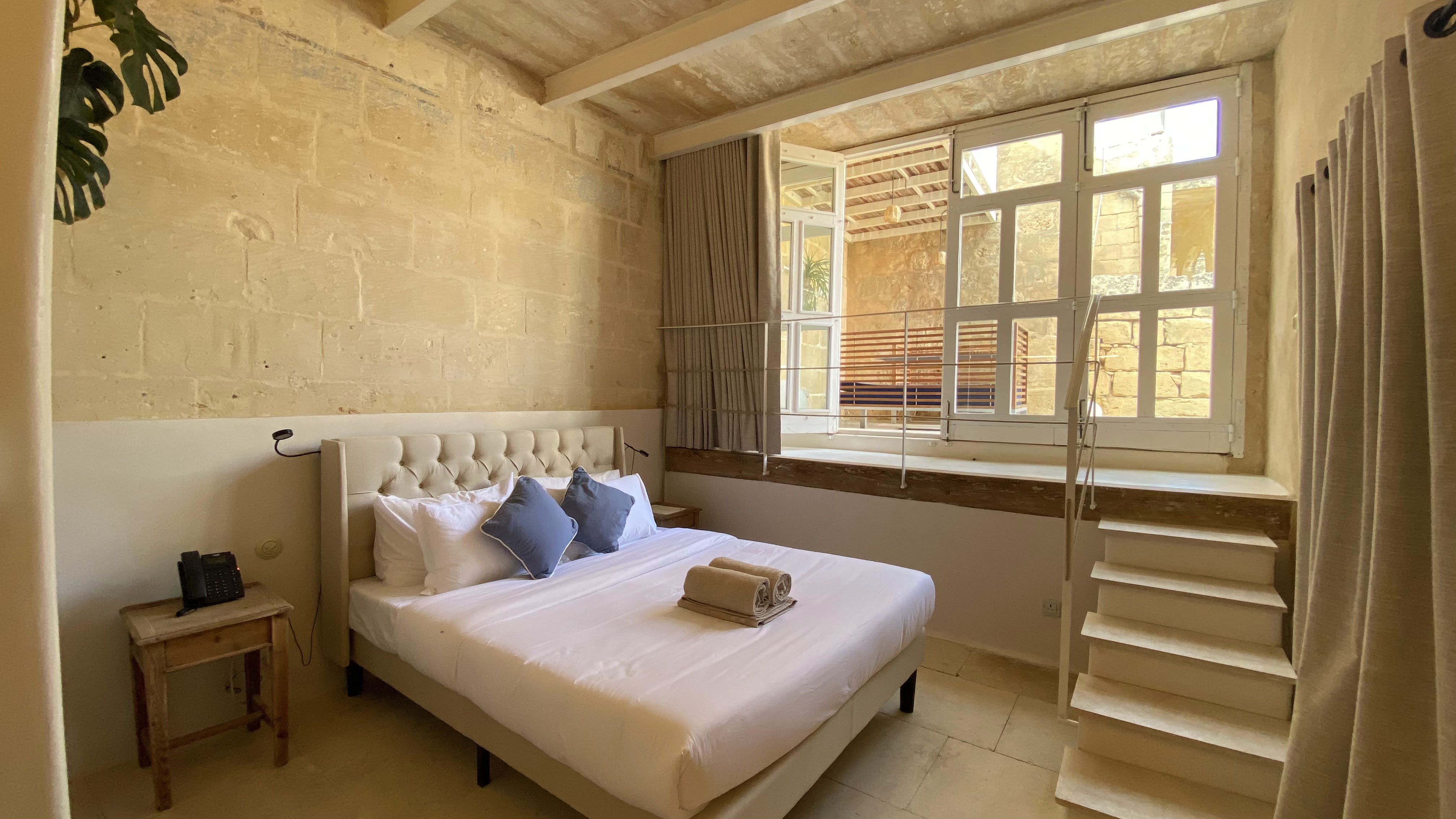 Bright rustic bedroom with a plush bed and charming window nook