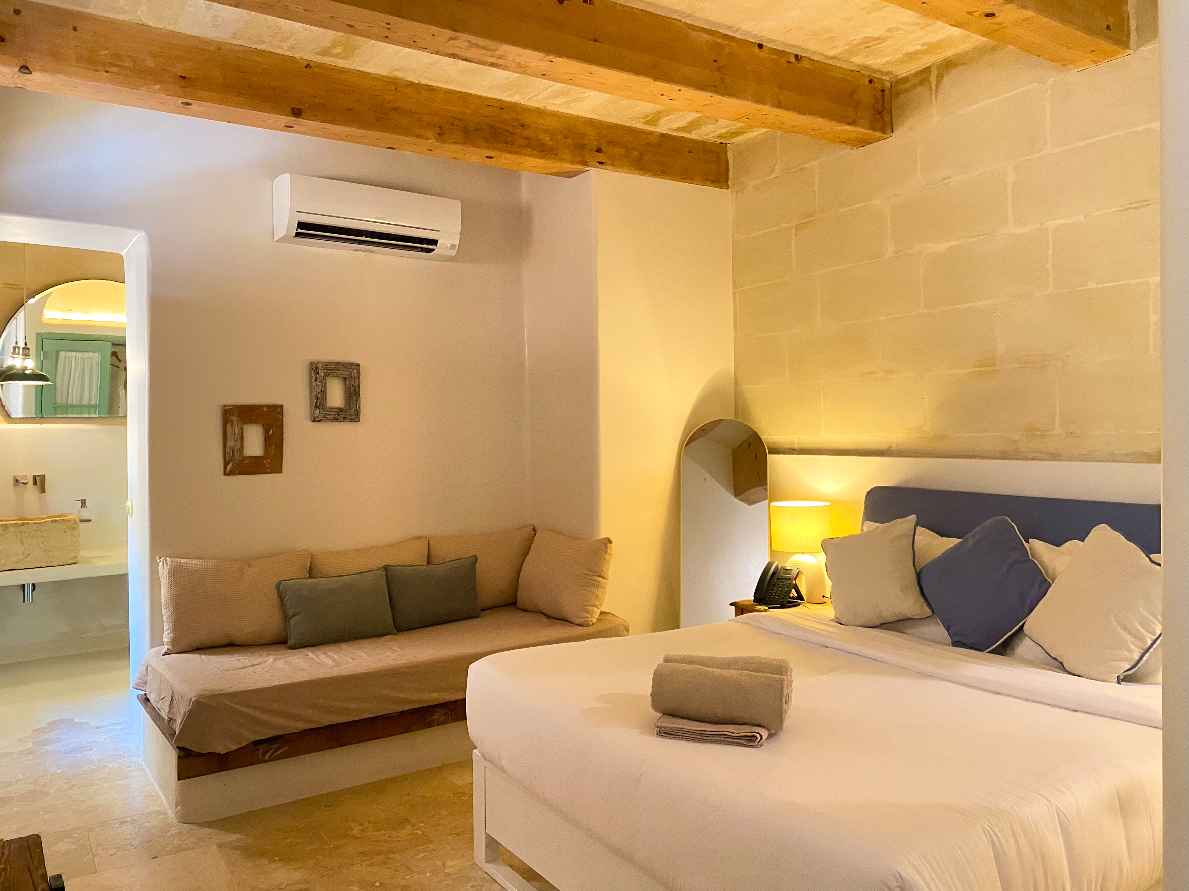 Cozy bedroom with exposed beams, daybed, and warm ambient lighting