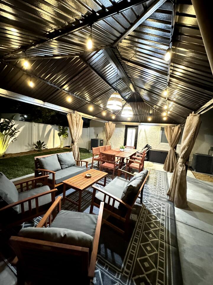 Beautiful covered backyard area lights up at night to enjoy family and friends in our relaxing backyard .