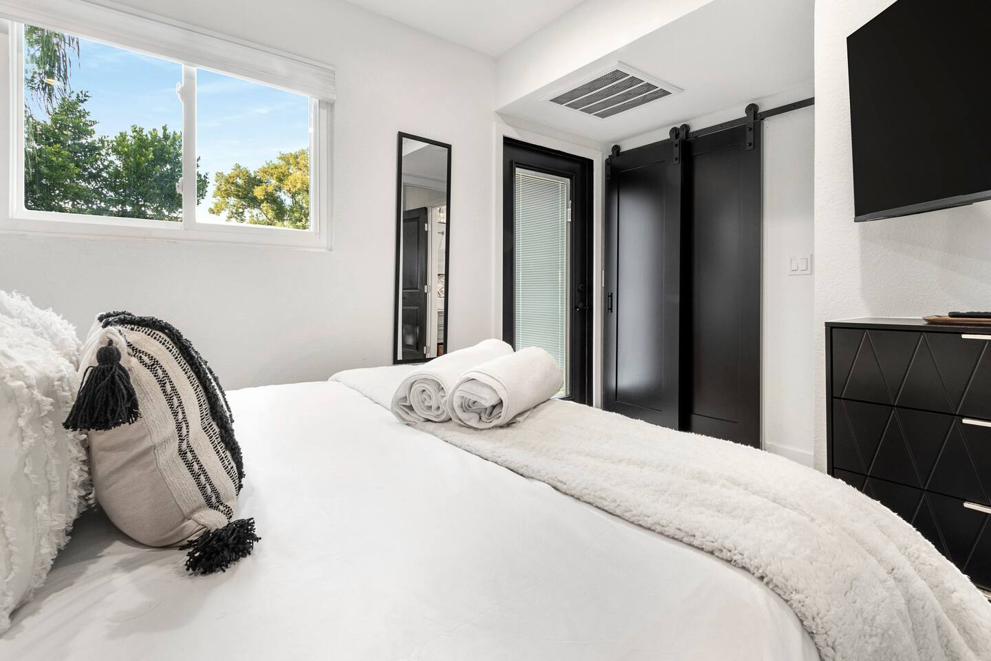 Queen bedroom with full length mirror , plenty of drawers & a closet for clothes & a luggage rack.