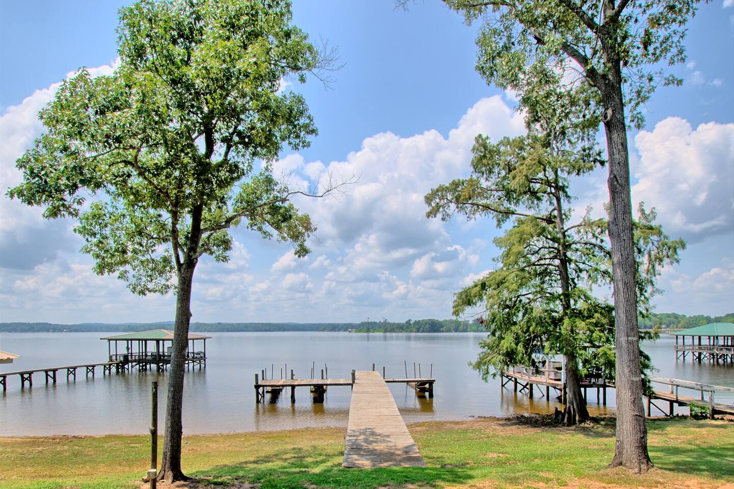 Private dock reaching into Toledo Bend Lake under tall trees