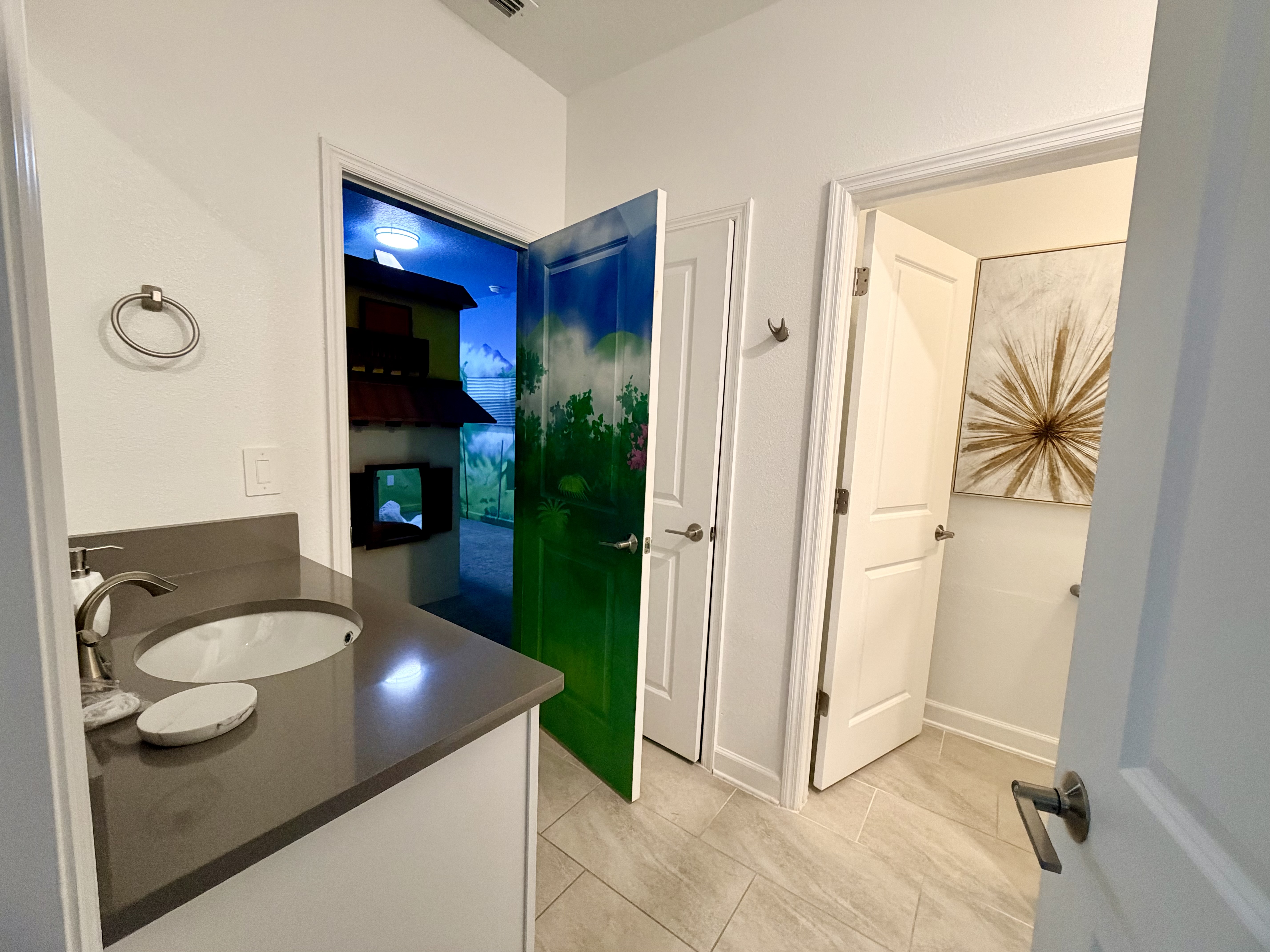 Bright modern bath with sleek vanity and a fun statement mural door