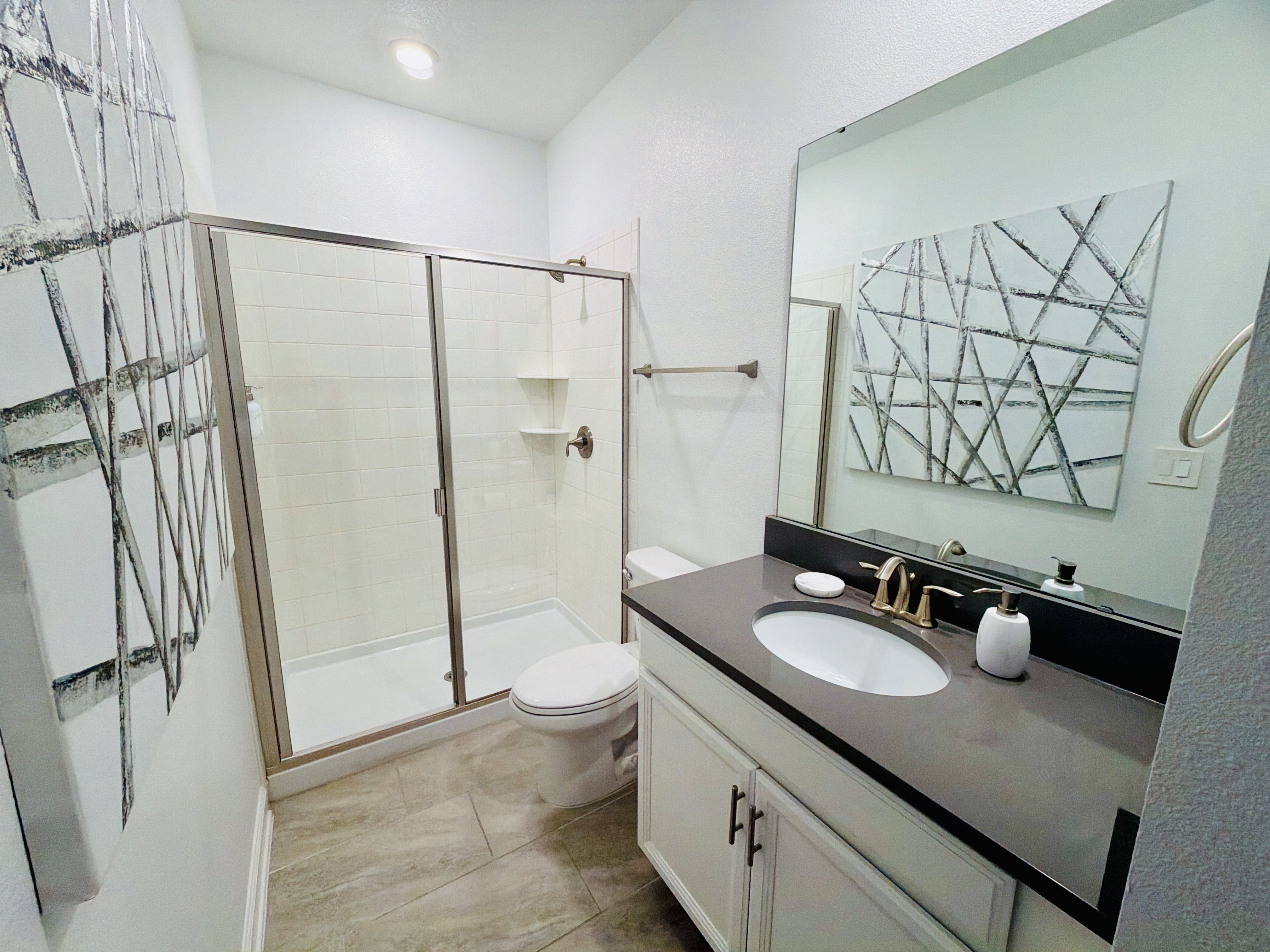 Bright modern bathroom with glass walk-in shower and a clean, sleek vanity