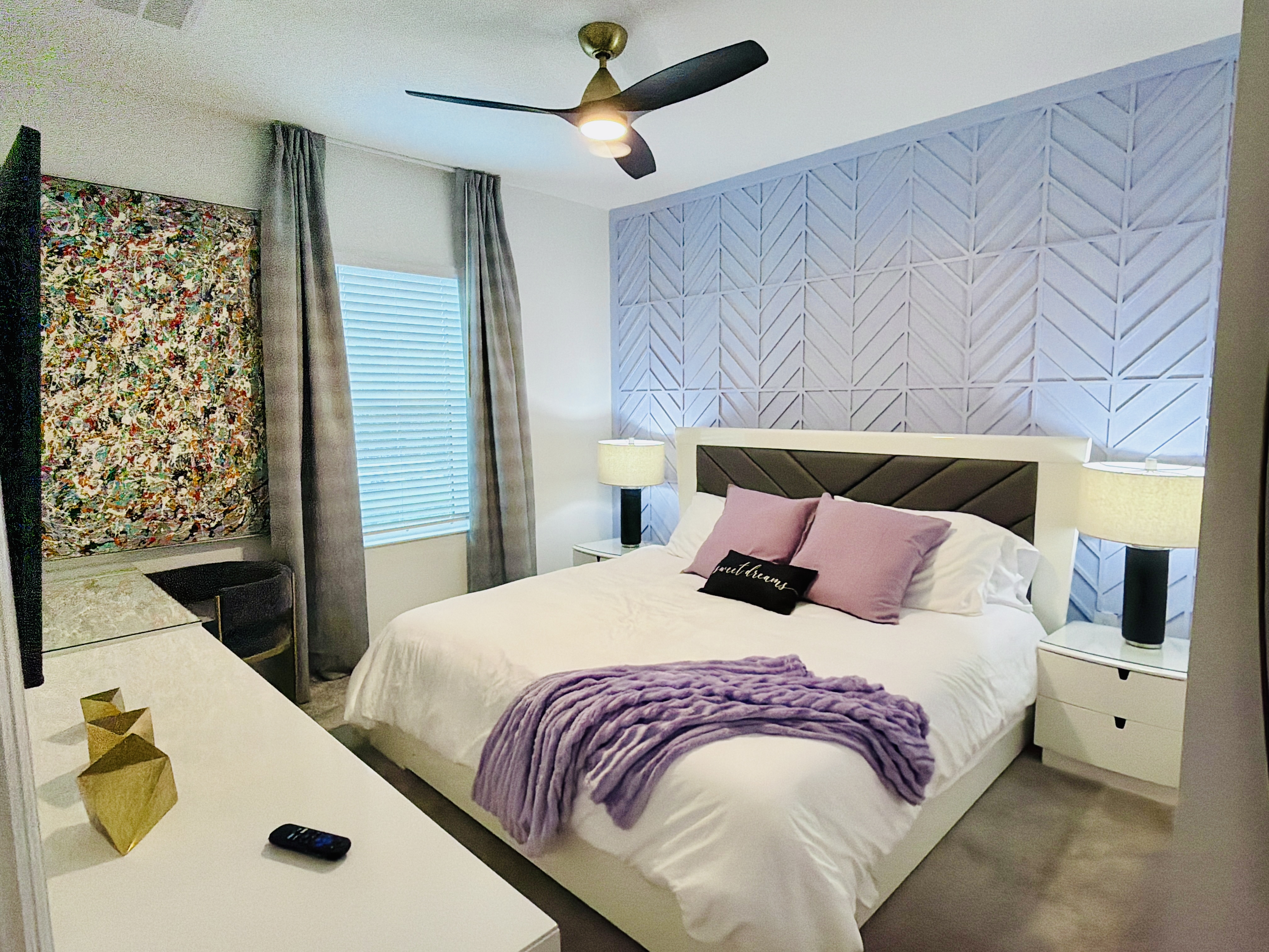 Modern bedroom with king bed, designer accent wall, and cozy touches