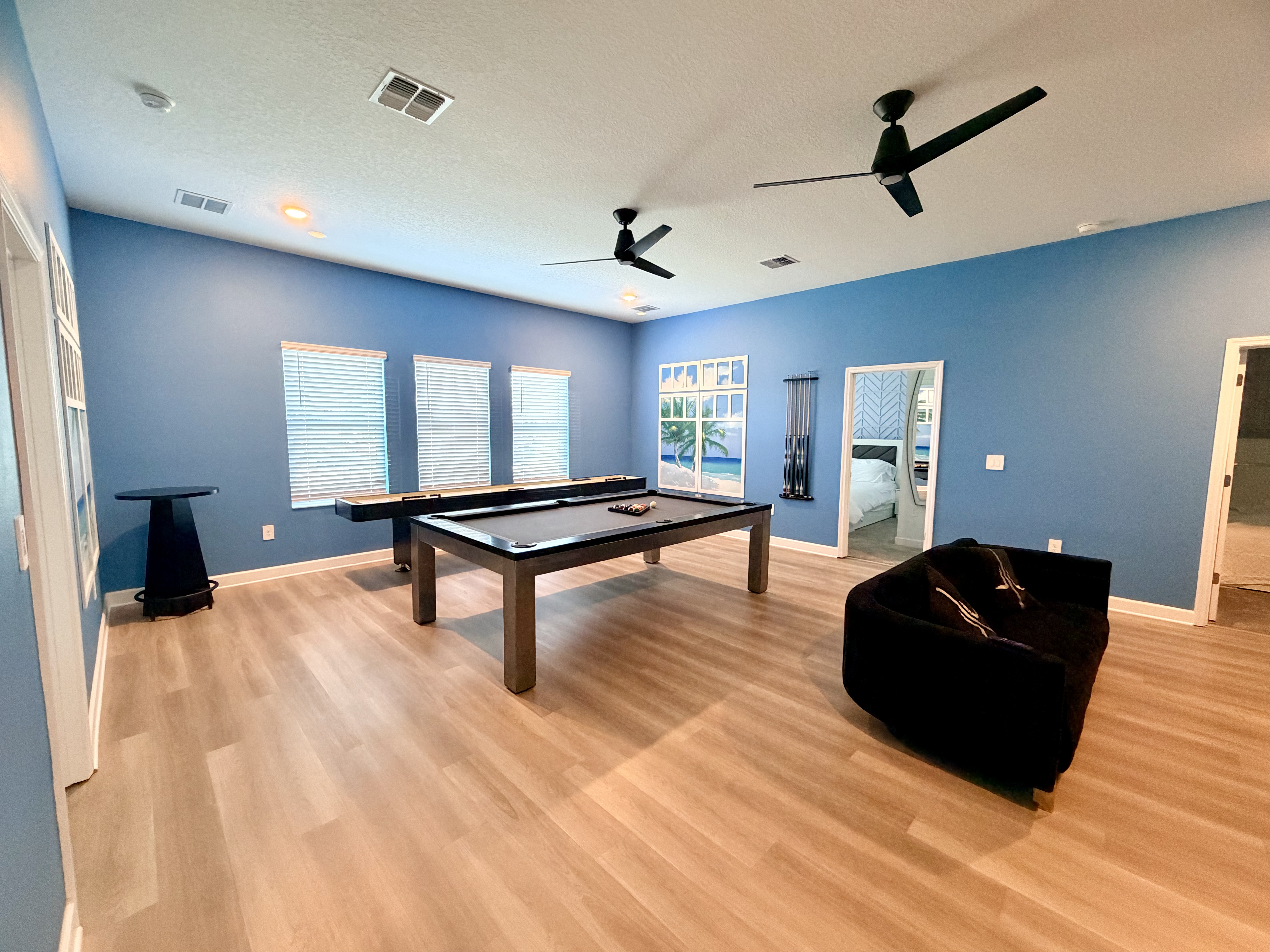 Spacious game room with pool table, natural light, and modern style