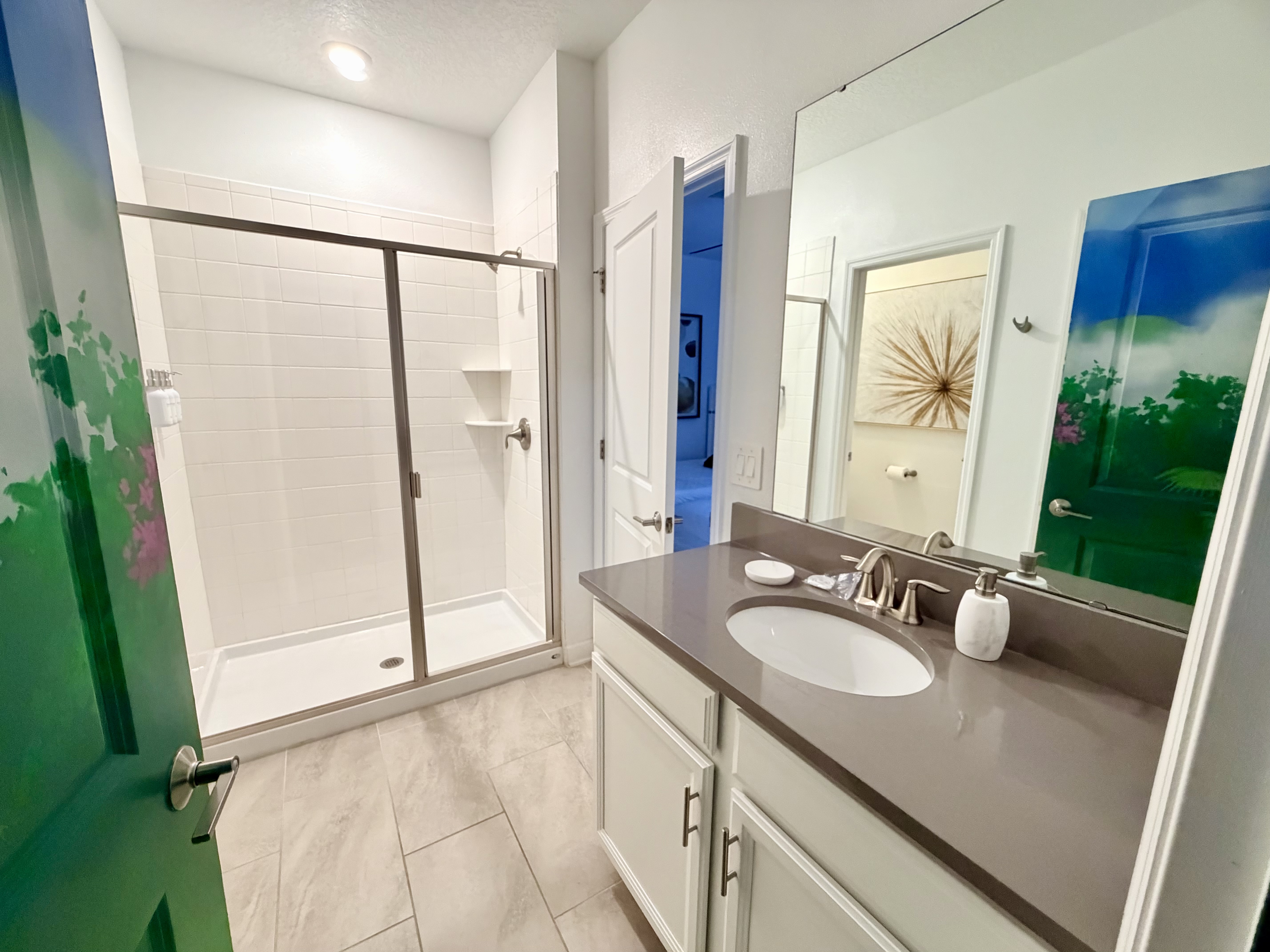 Bright modern bathroom with large vanity and glass walk-in shower