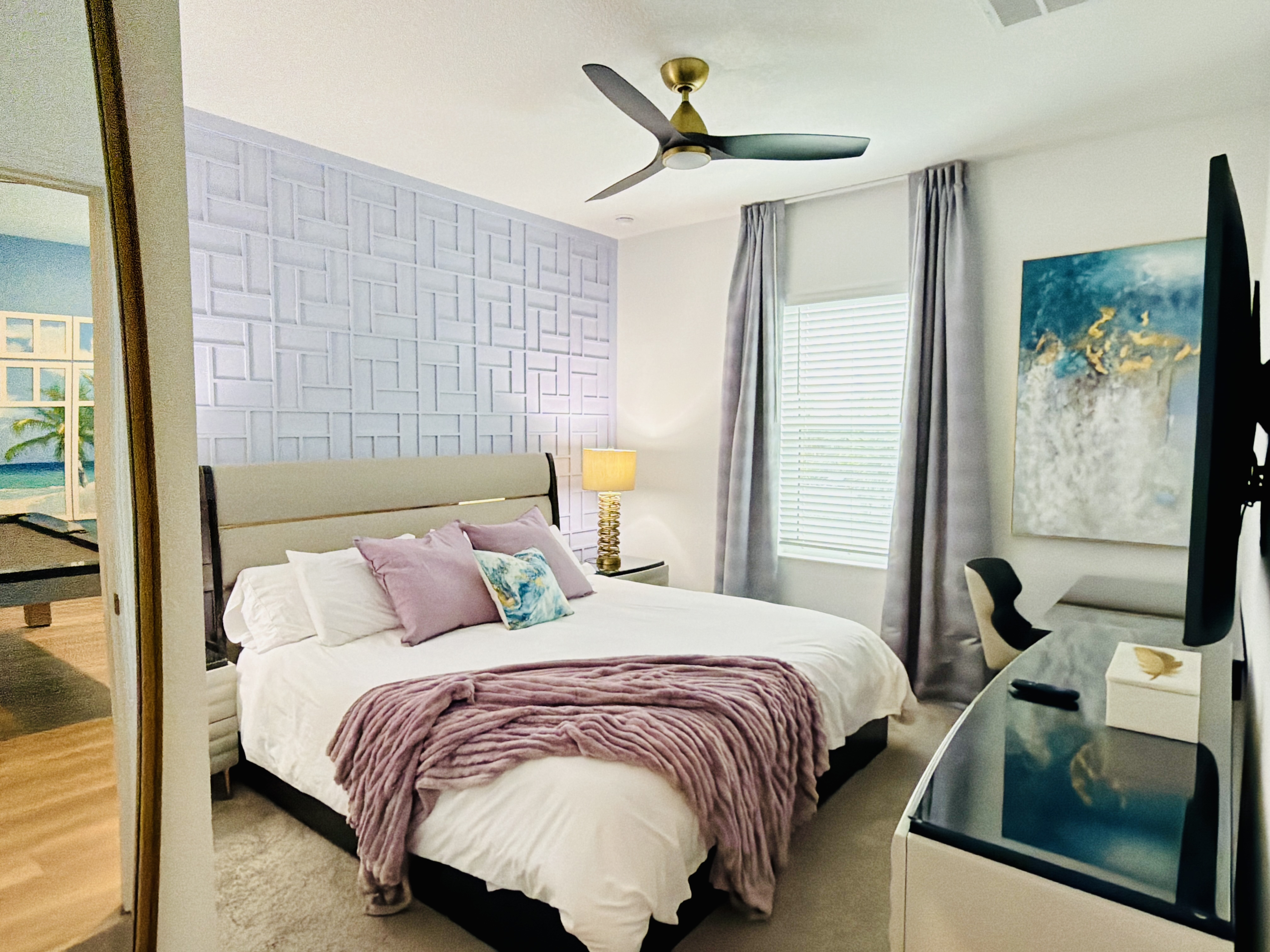 Bright, modern bedroom with plush bedding, workspace, and elegant decor