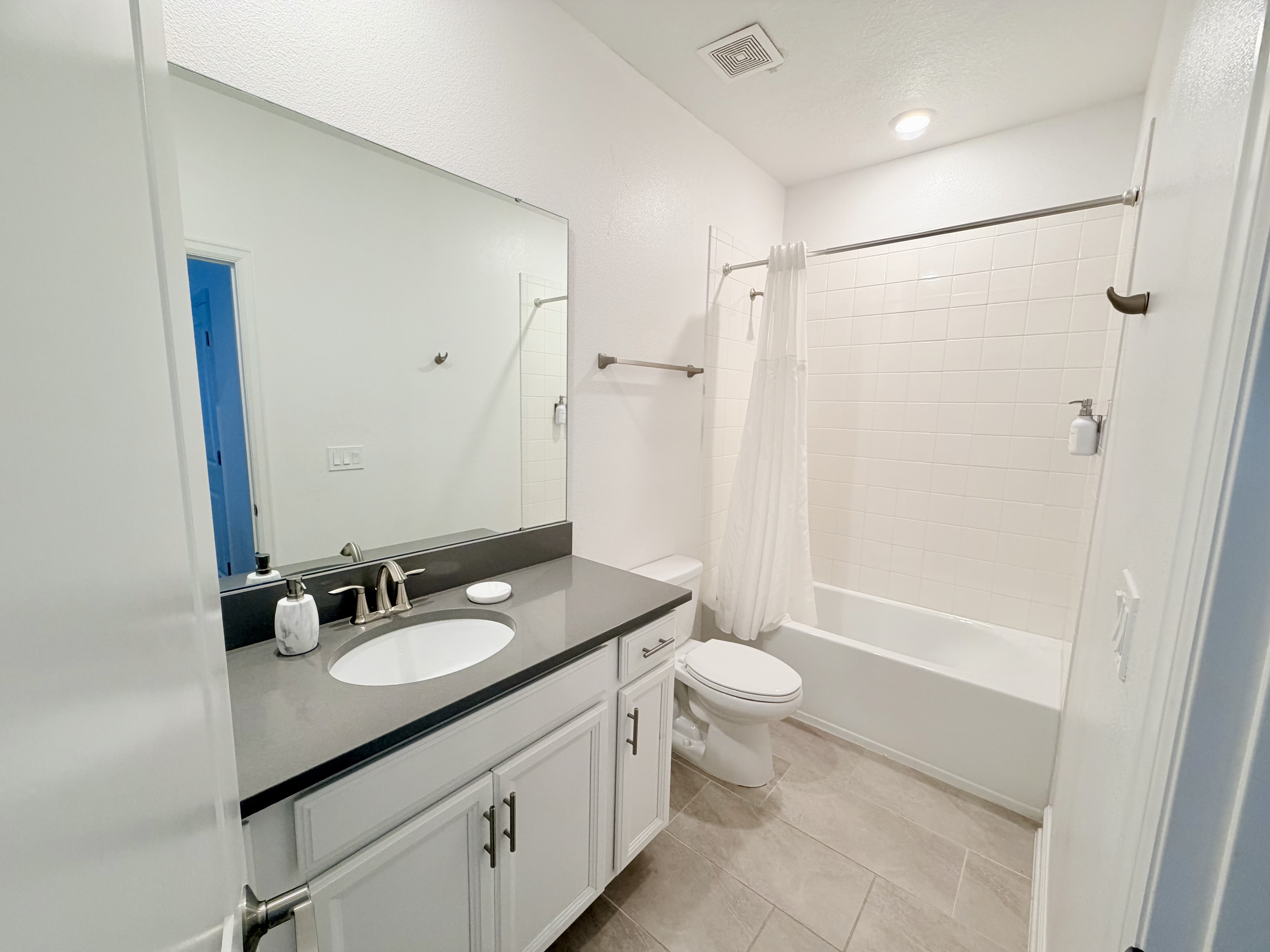 Bright, modern full bath with tub-shower combo and sleek vanity