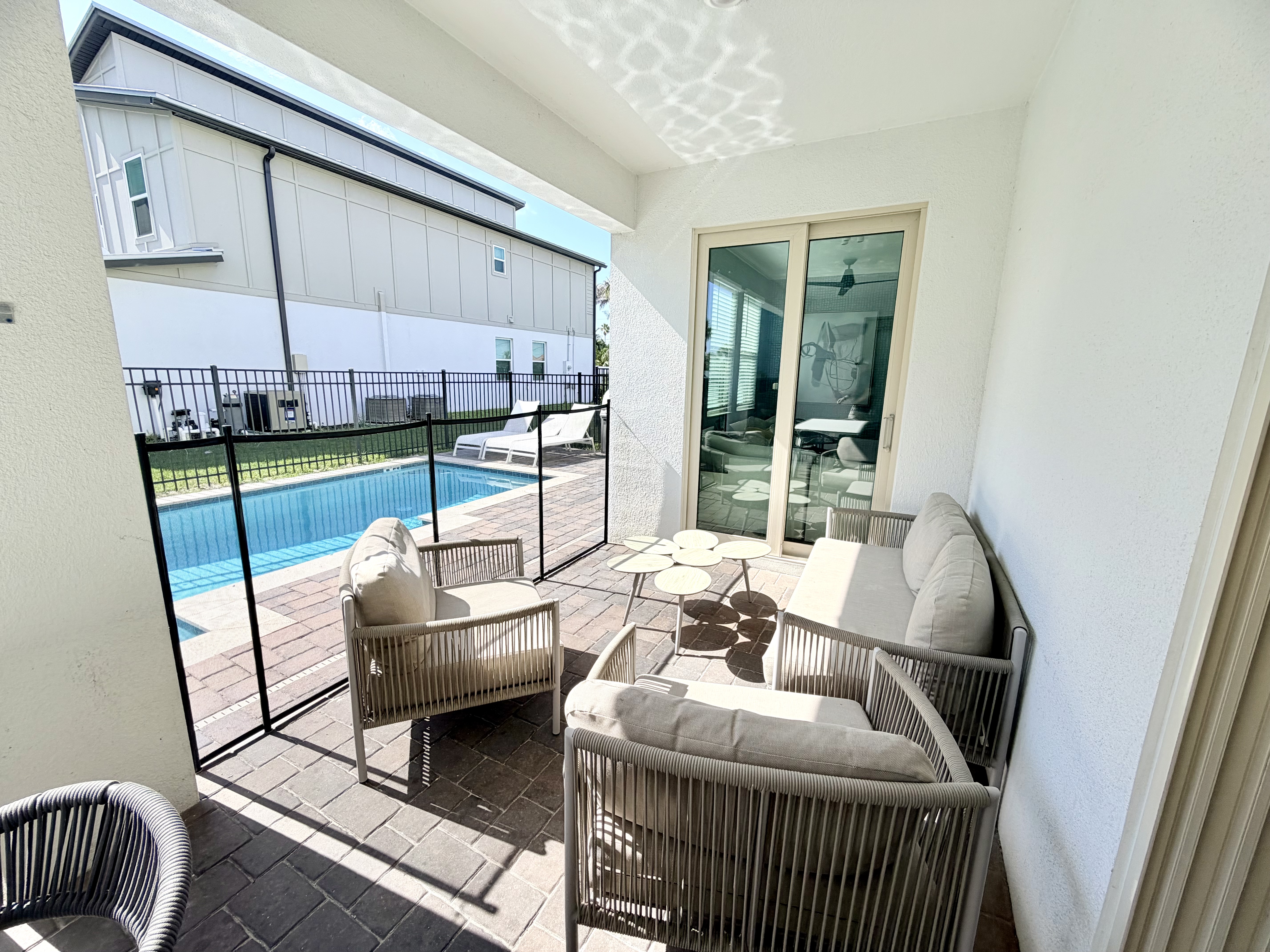 Covered poolside patio with cozy seating and easy indoor-outdoor flow