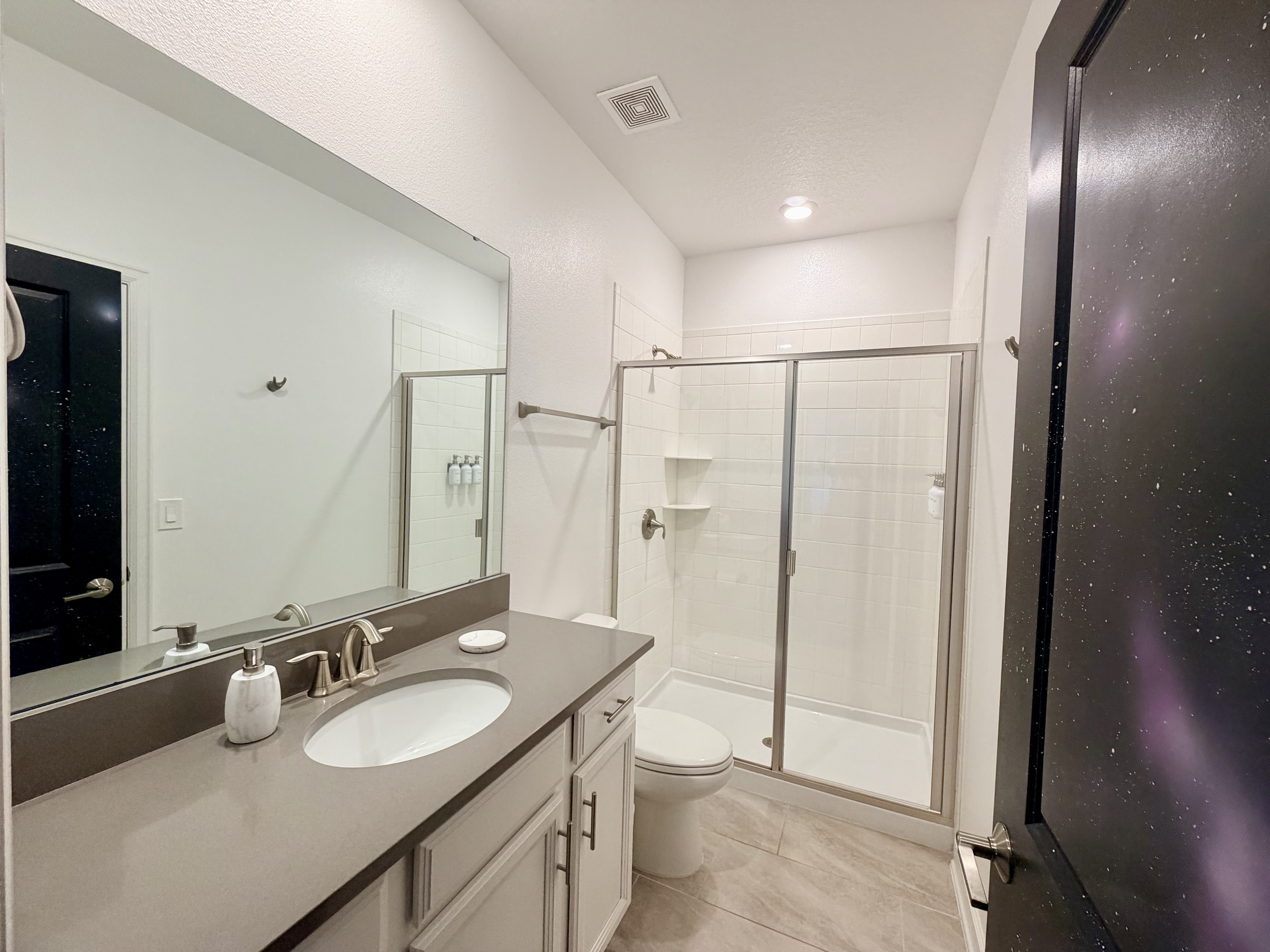 Bright modern bathroom with large vanity and glass walk-in shower