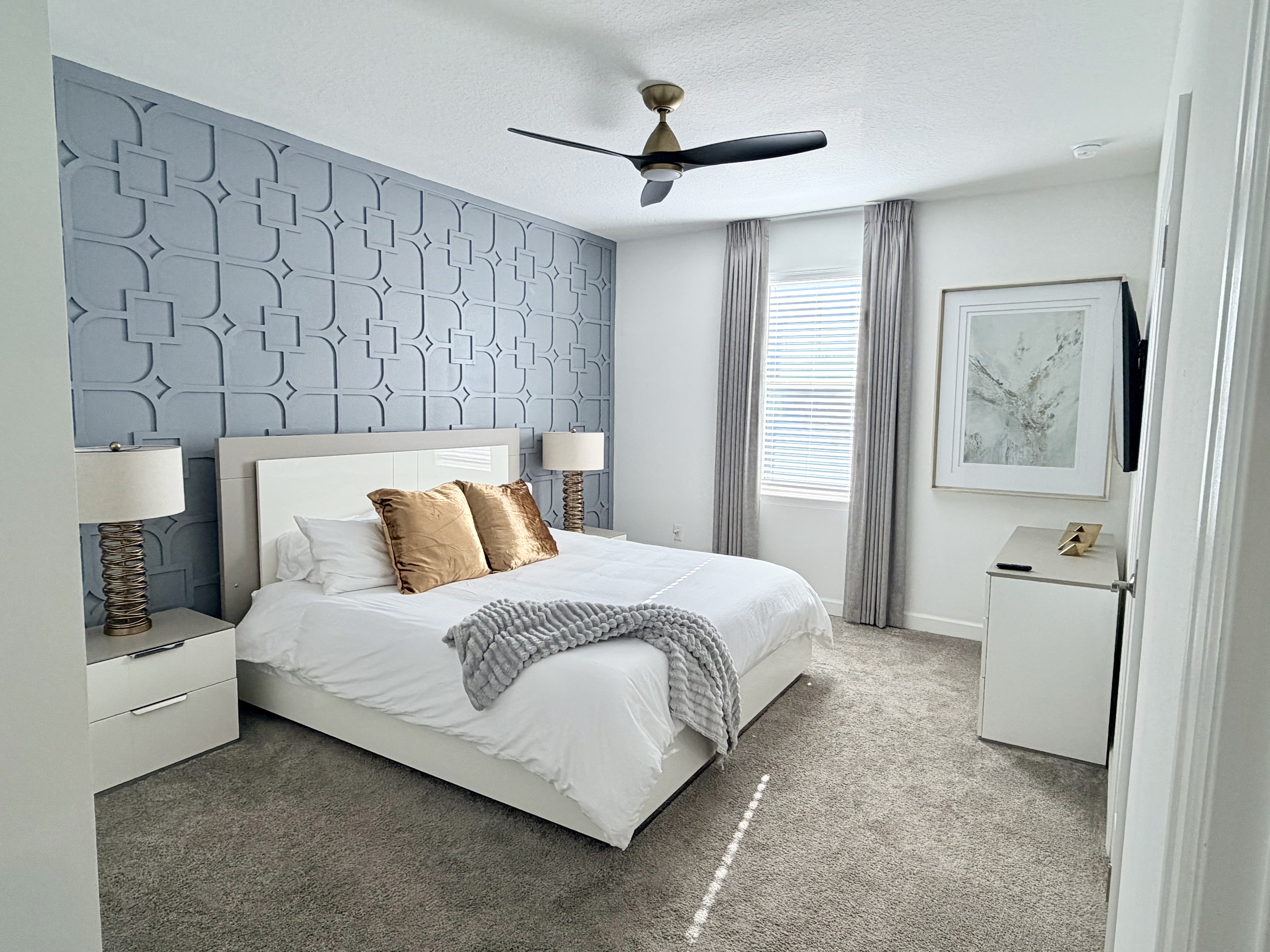Bright modern bedroom with designer accent wall and plush king bed