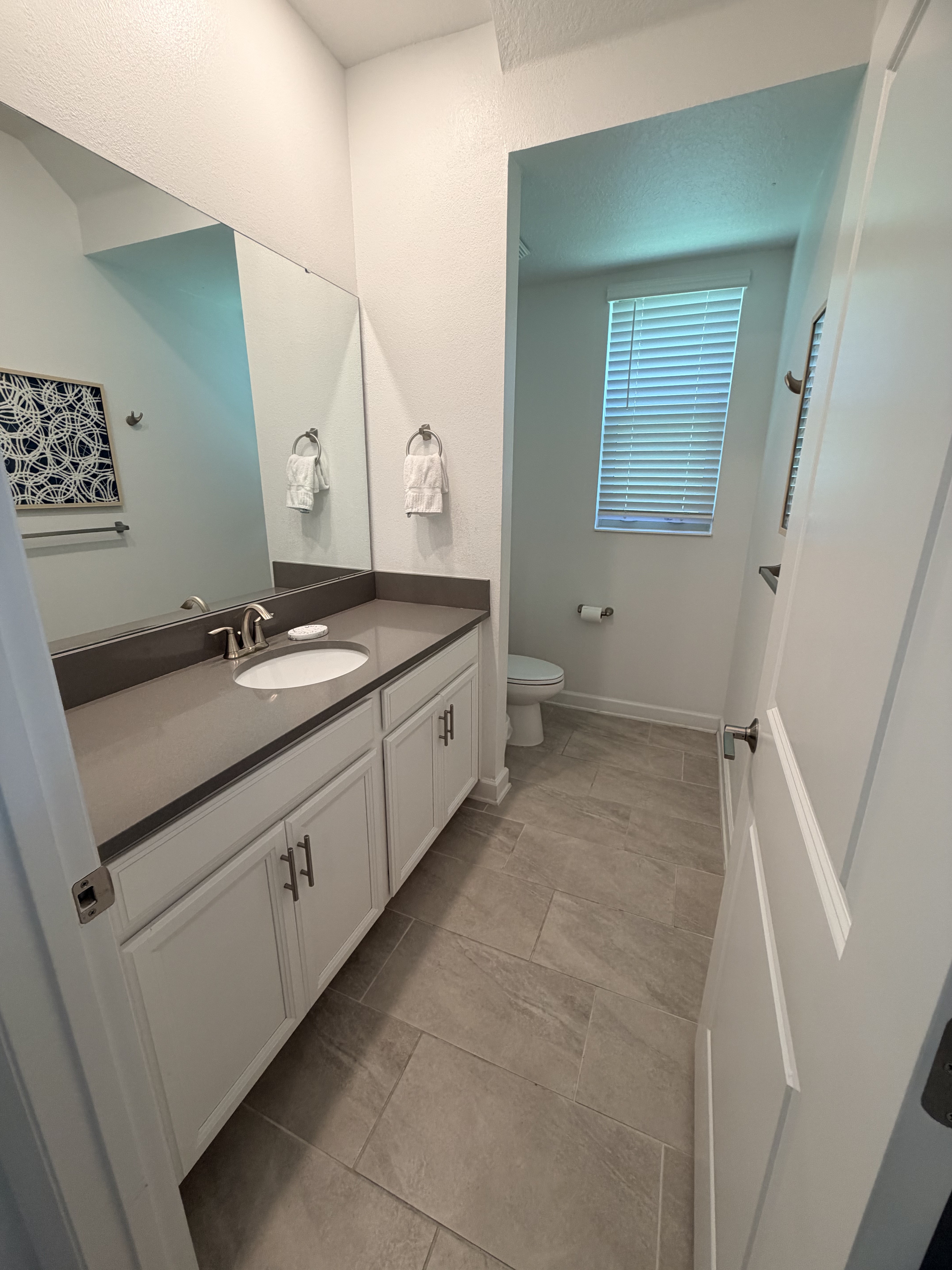 Spacious modern bathroom with double vanity and sleek gray tile
