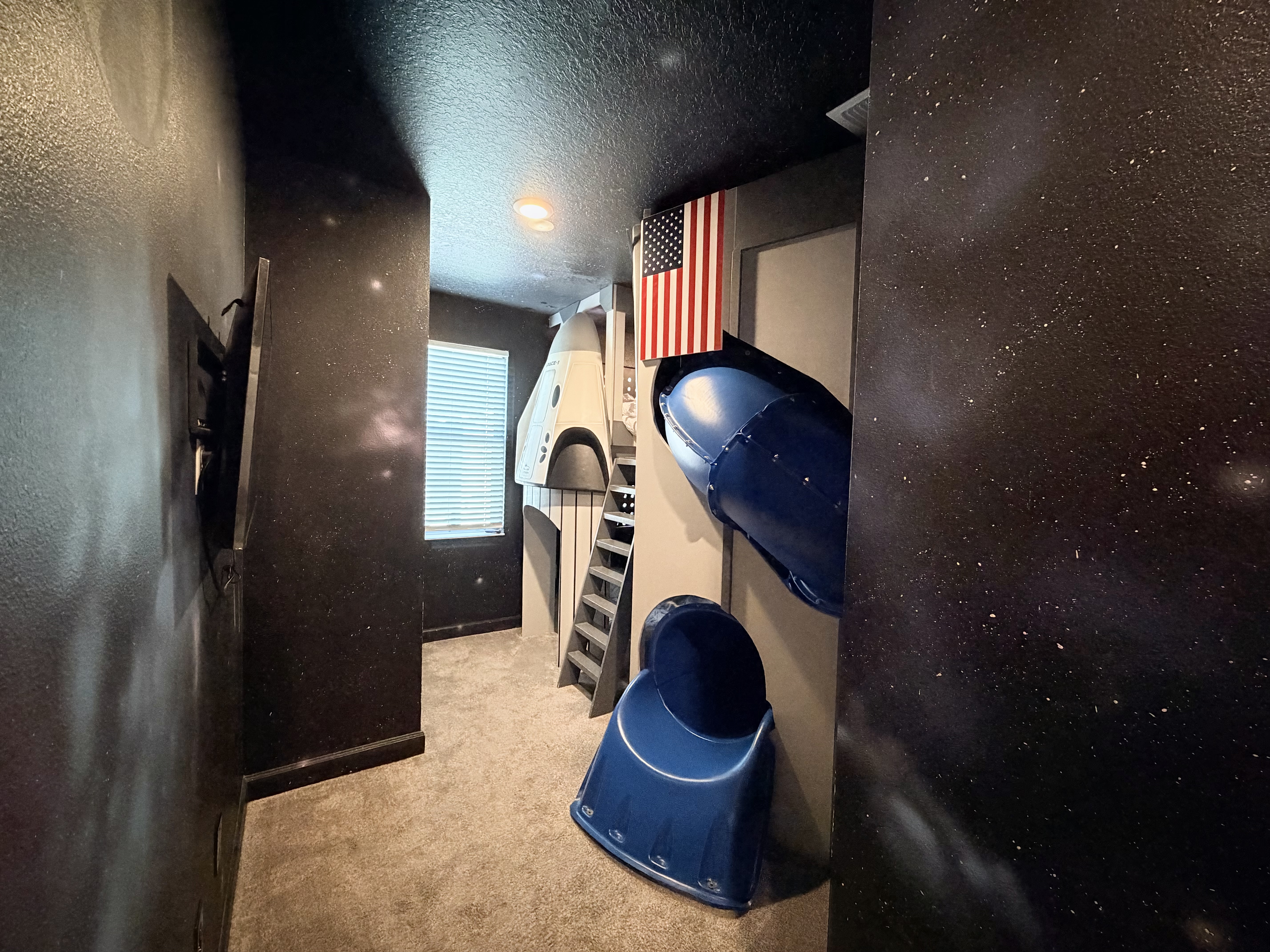 Fun space-themed bunk room with built-in slide for the kids