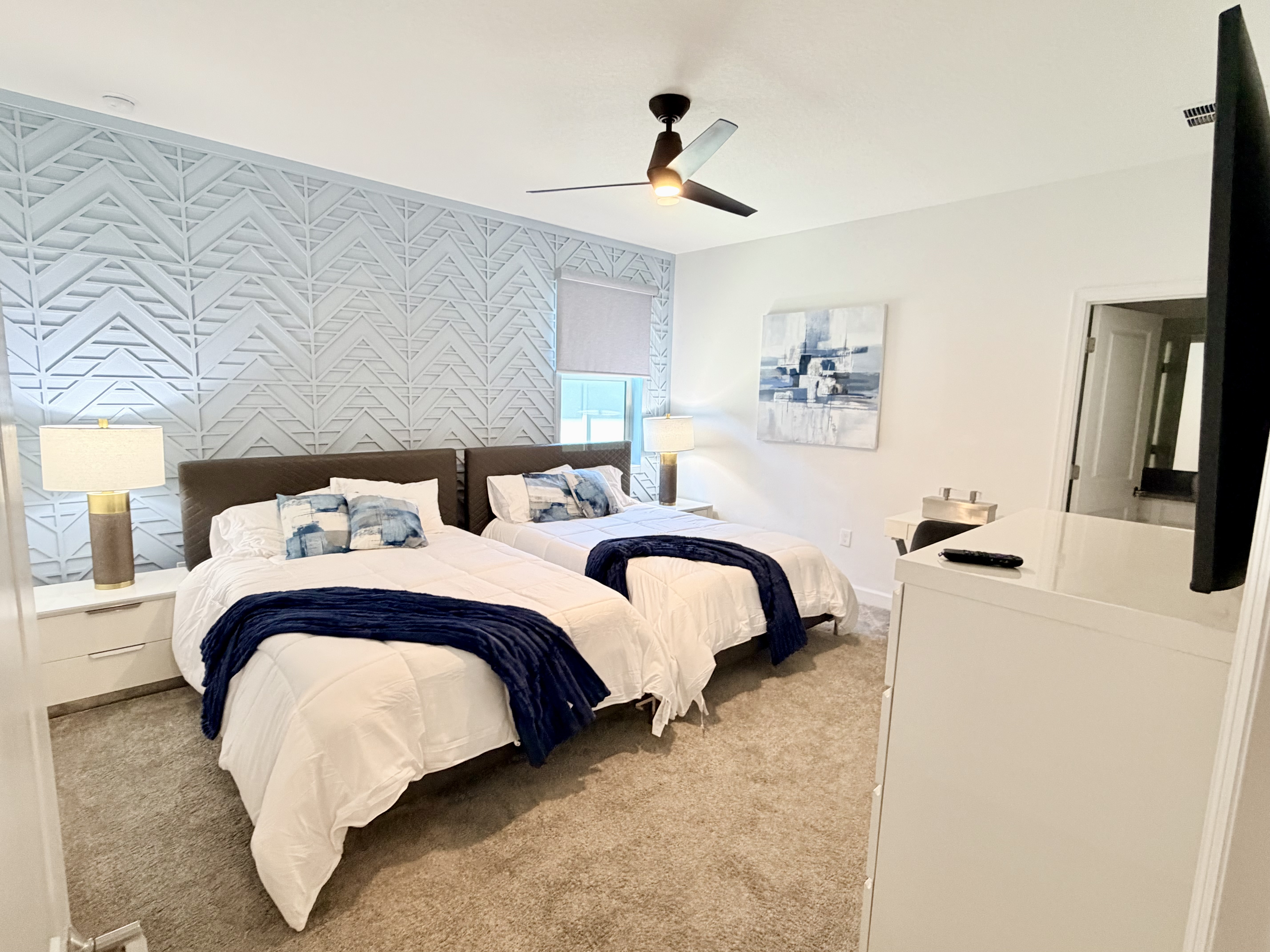 Bright double-bedroom with stylish accent wall and cozy modern touches