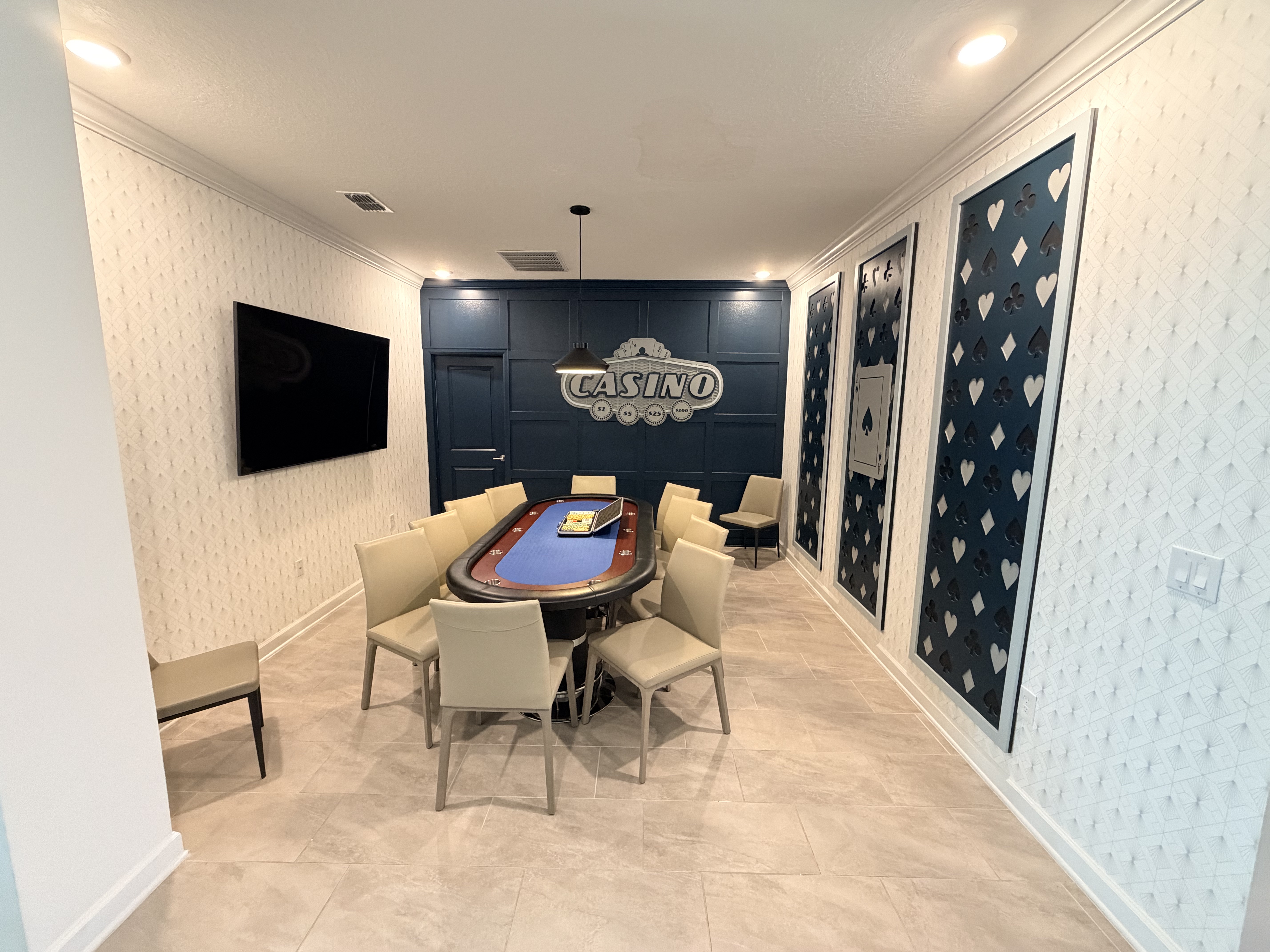 Elegant casino-themed game room with poker table and TV for group fun