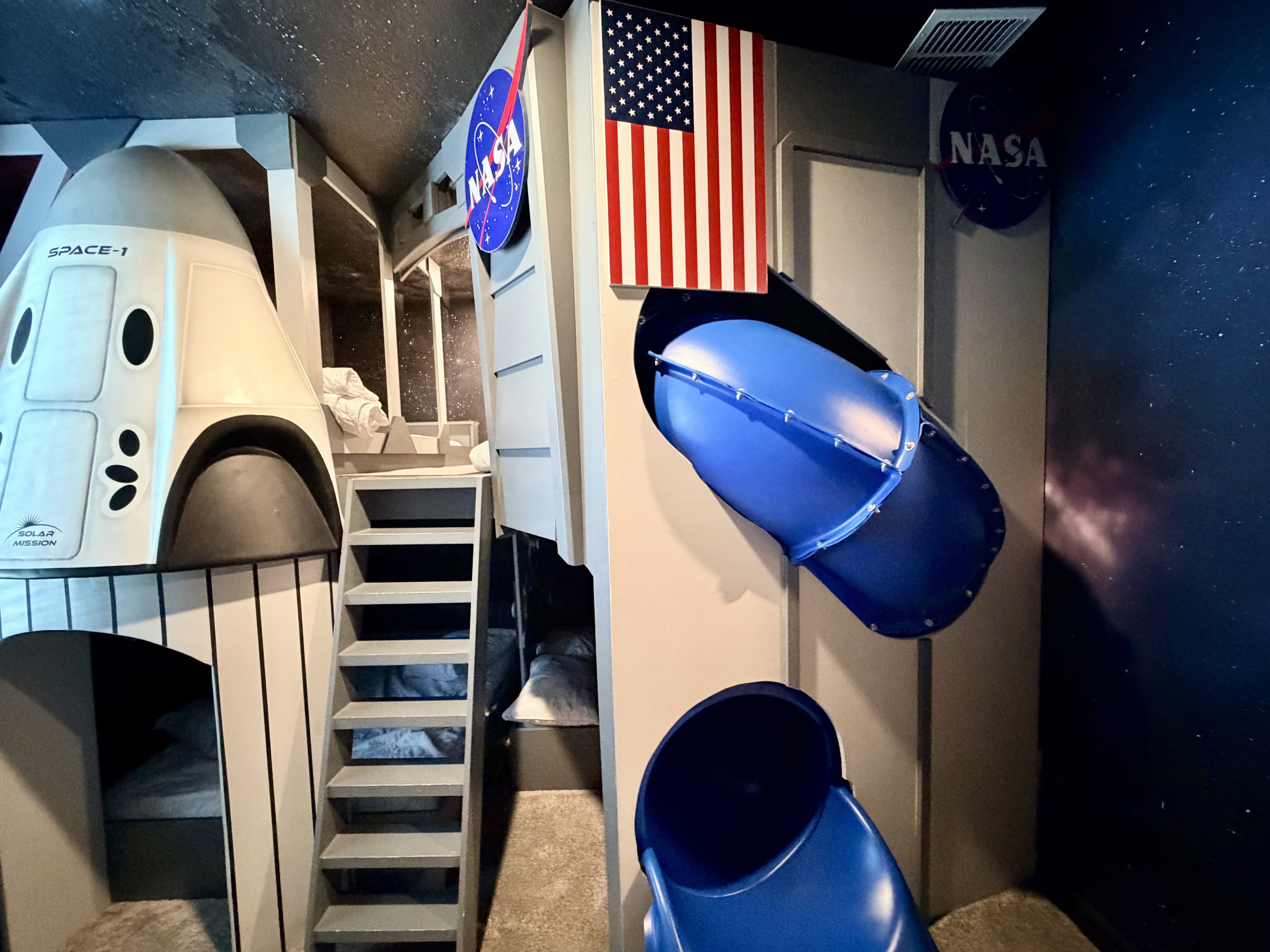 Epic NASA-themed bunk room with rocket bed and galaxy-inspired decor