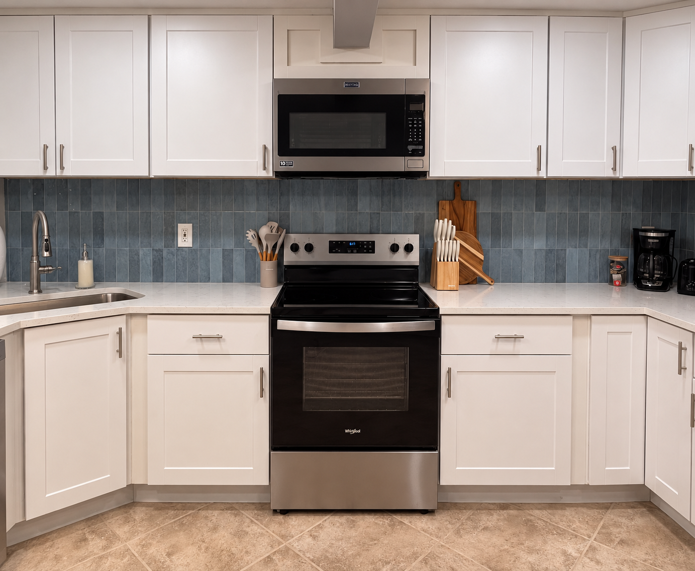 Bright modern kitchen with stainless appliances and stylish blue backsplash