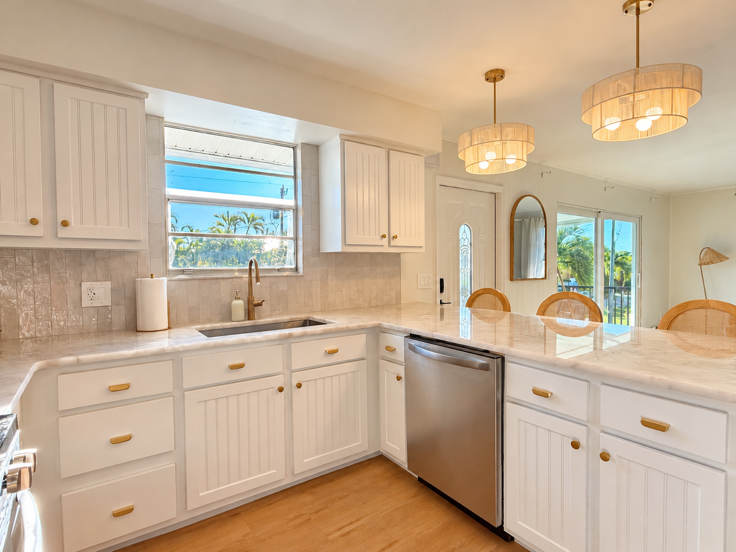Bright coastal kitchen with peninsula seating and sunny dining views