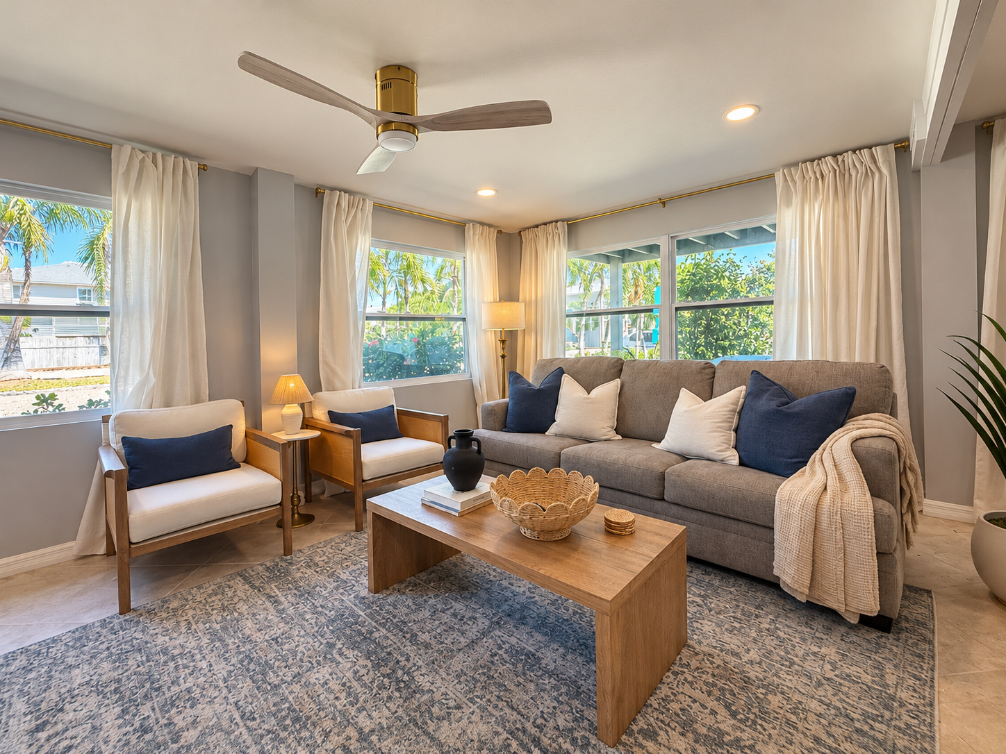 Bright, stylish living room with natural light and cozy seating. Tide Suite
