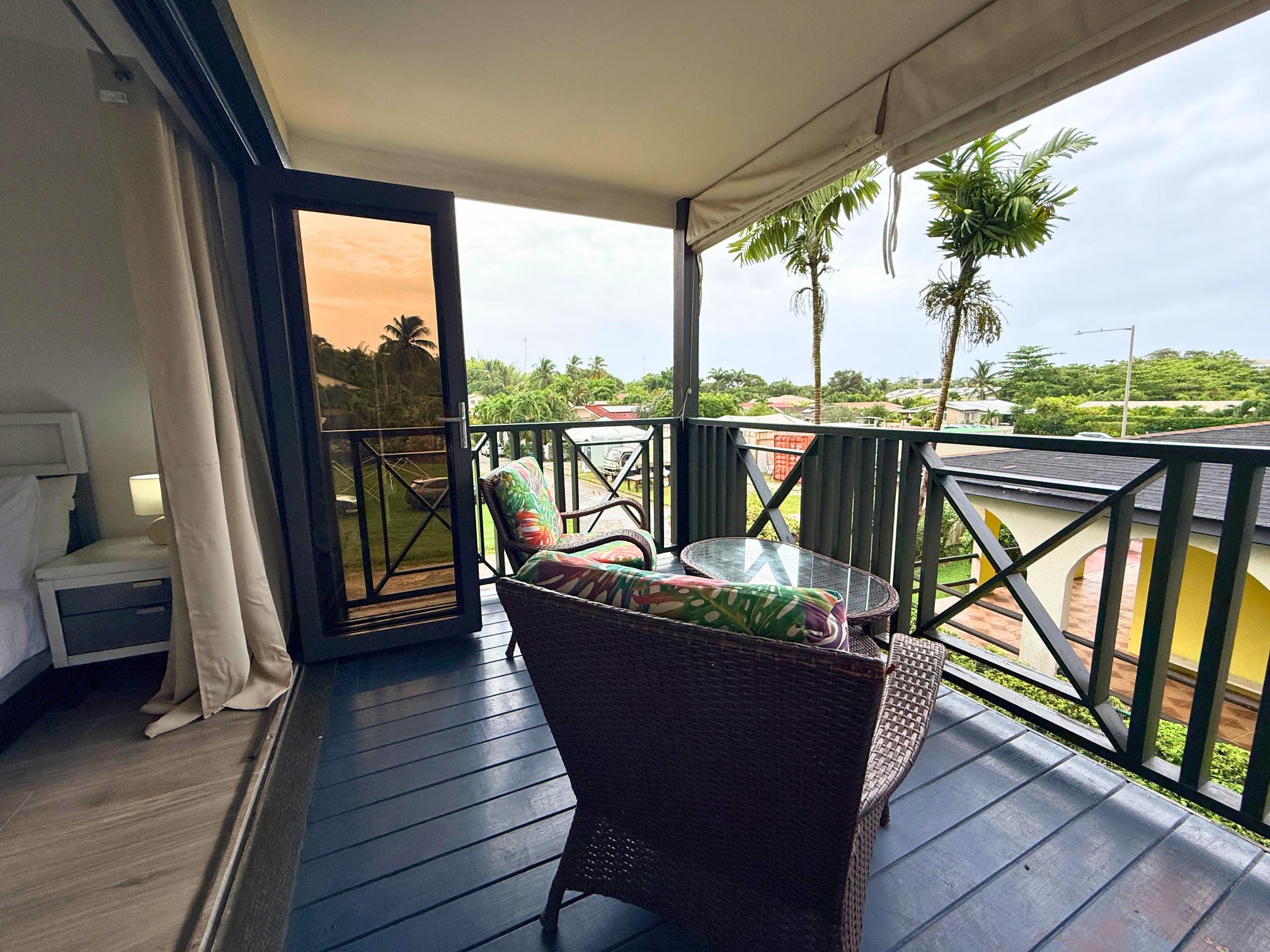 Private covered balcony with tropical views and cozy seating