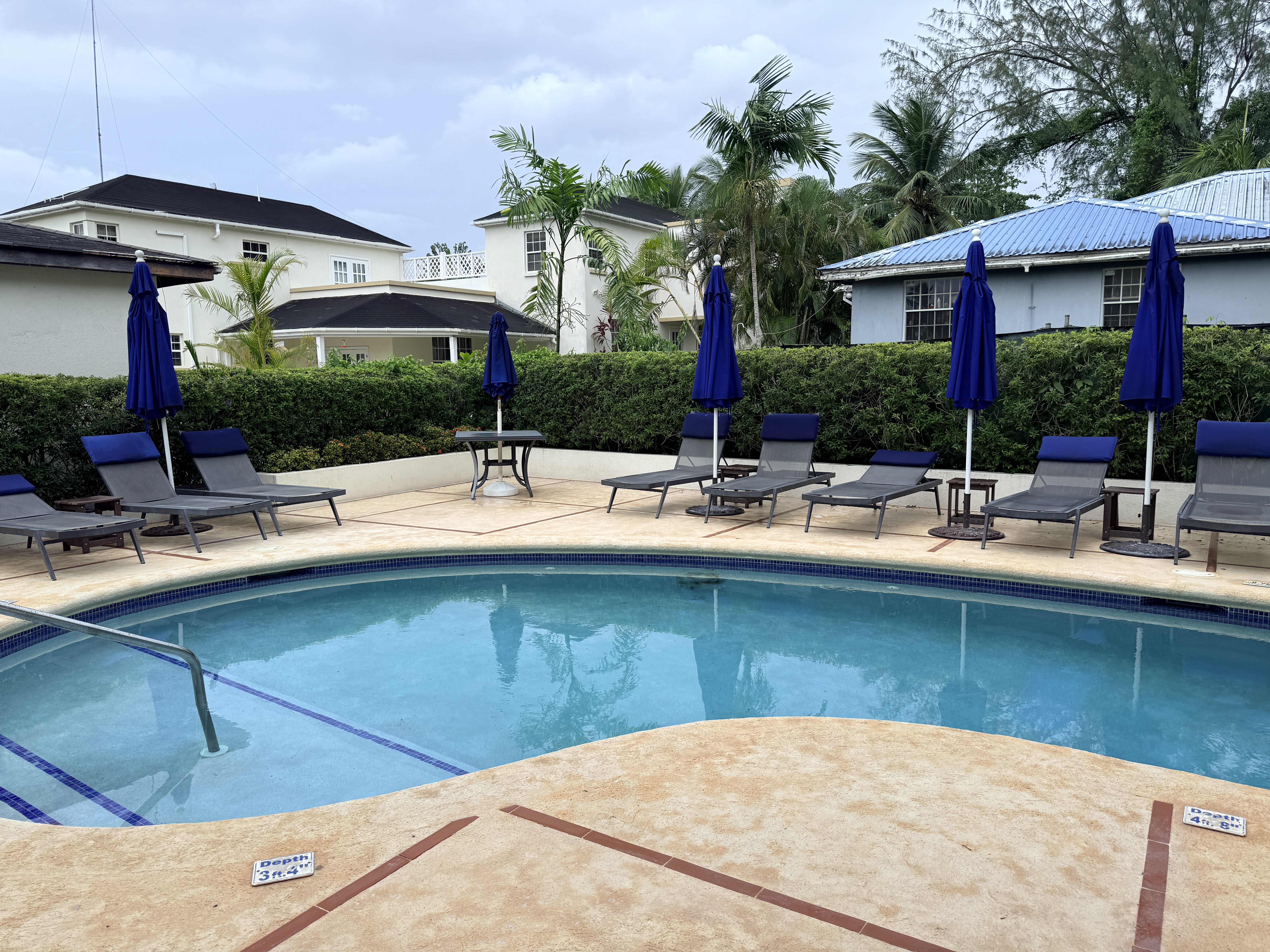 Resort-style pool with loungers, umbrellas, and tropical surroundings