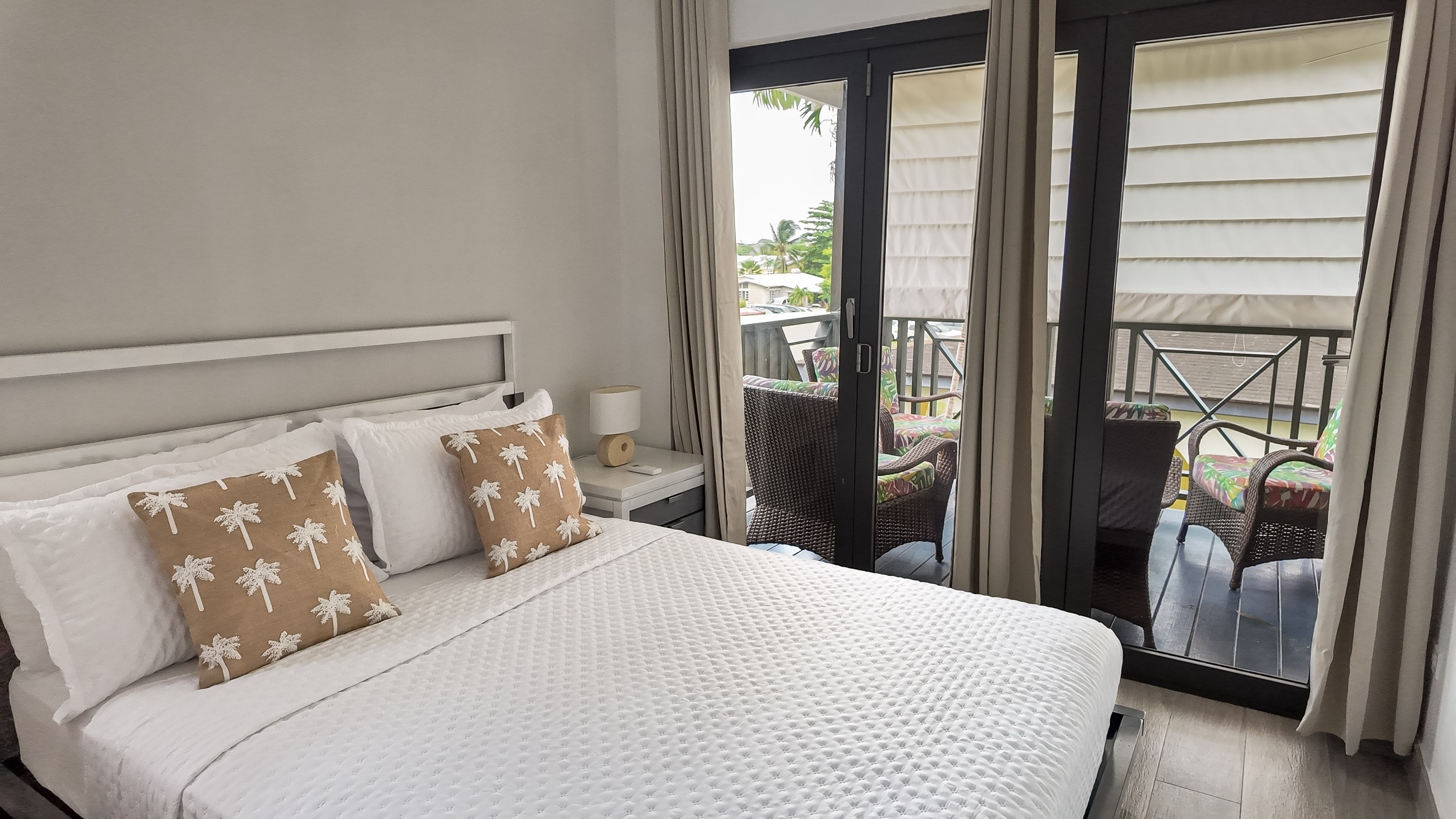 Bright bedroom with private balcony seating and tropical touches