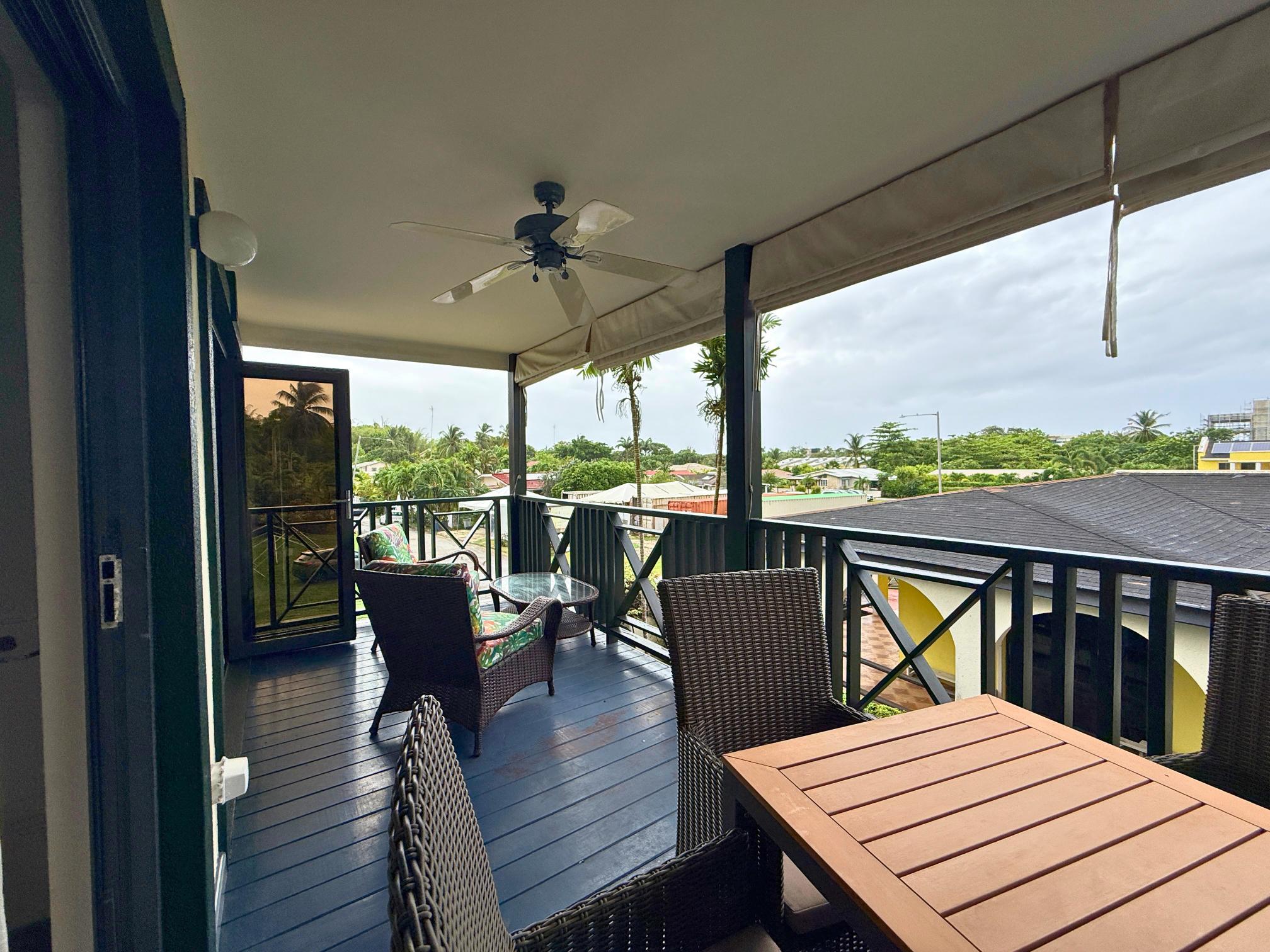 Spacious covered balcony with dining area, lounge seating, and breezy views