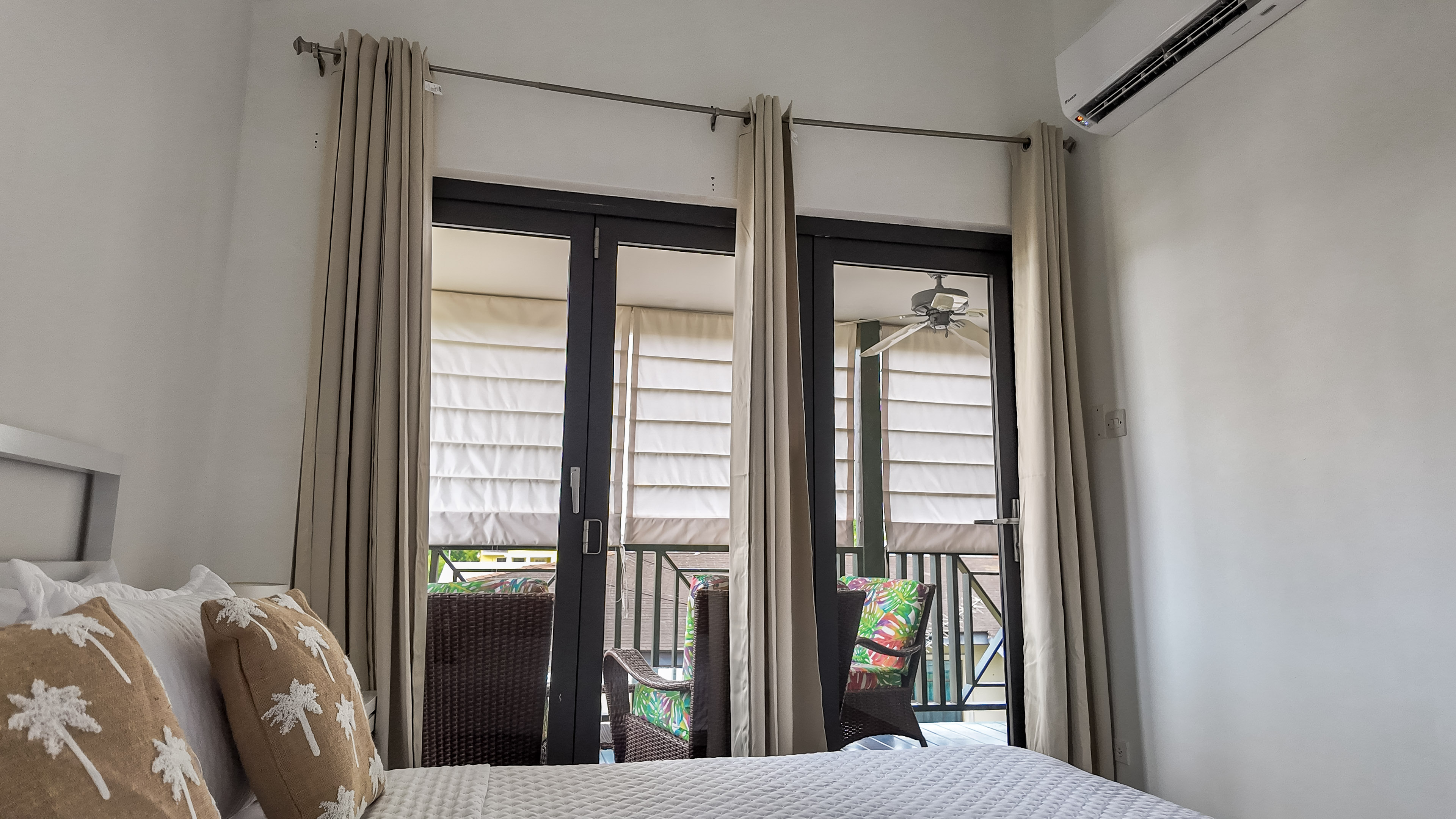 Bright bedroom with private balcony seating and AC