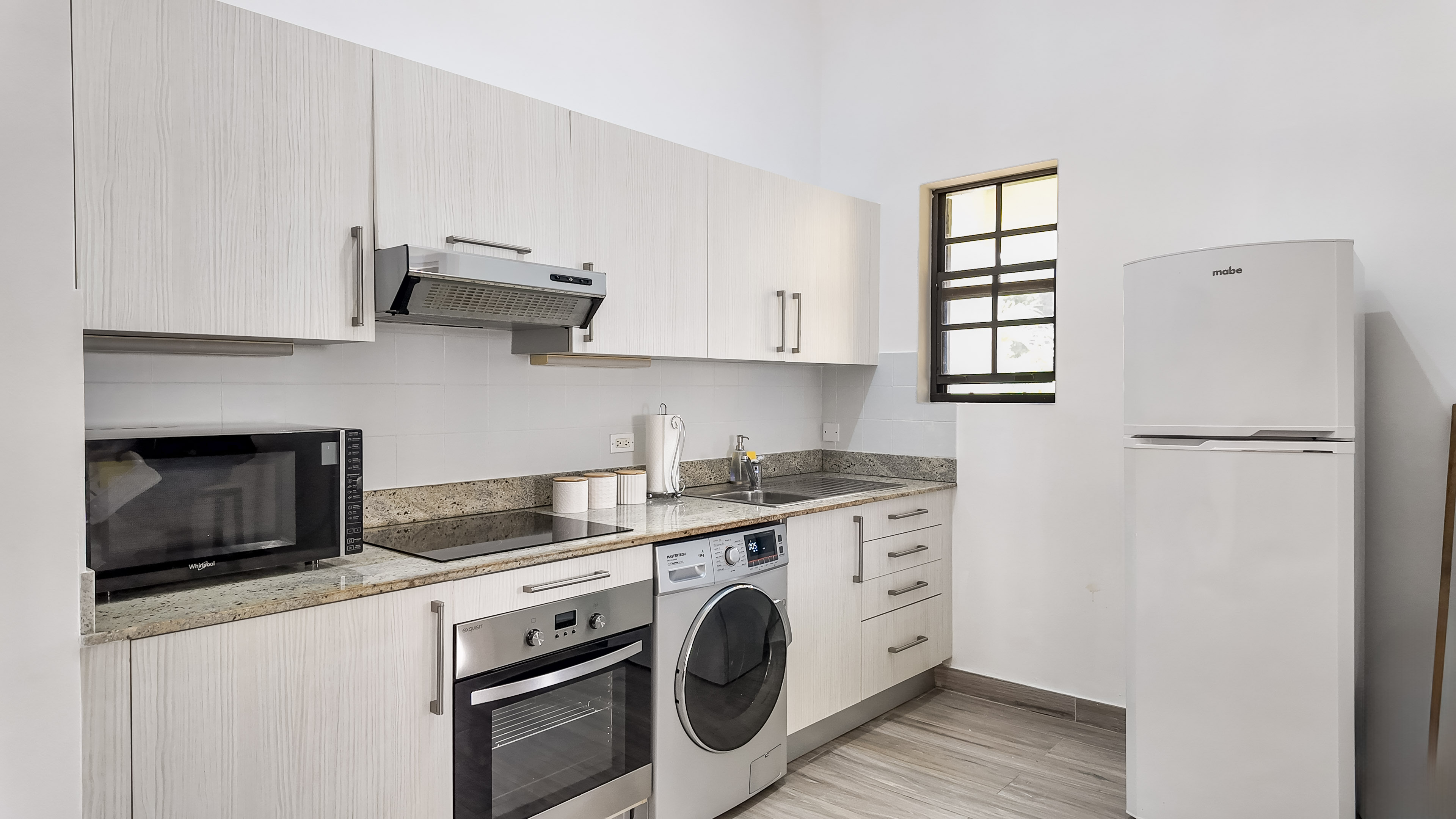 Bright modern kitchen with full appliances and in-unit washer