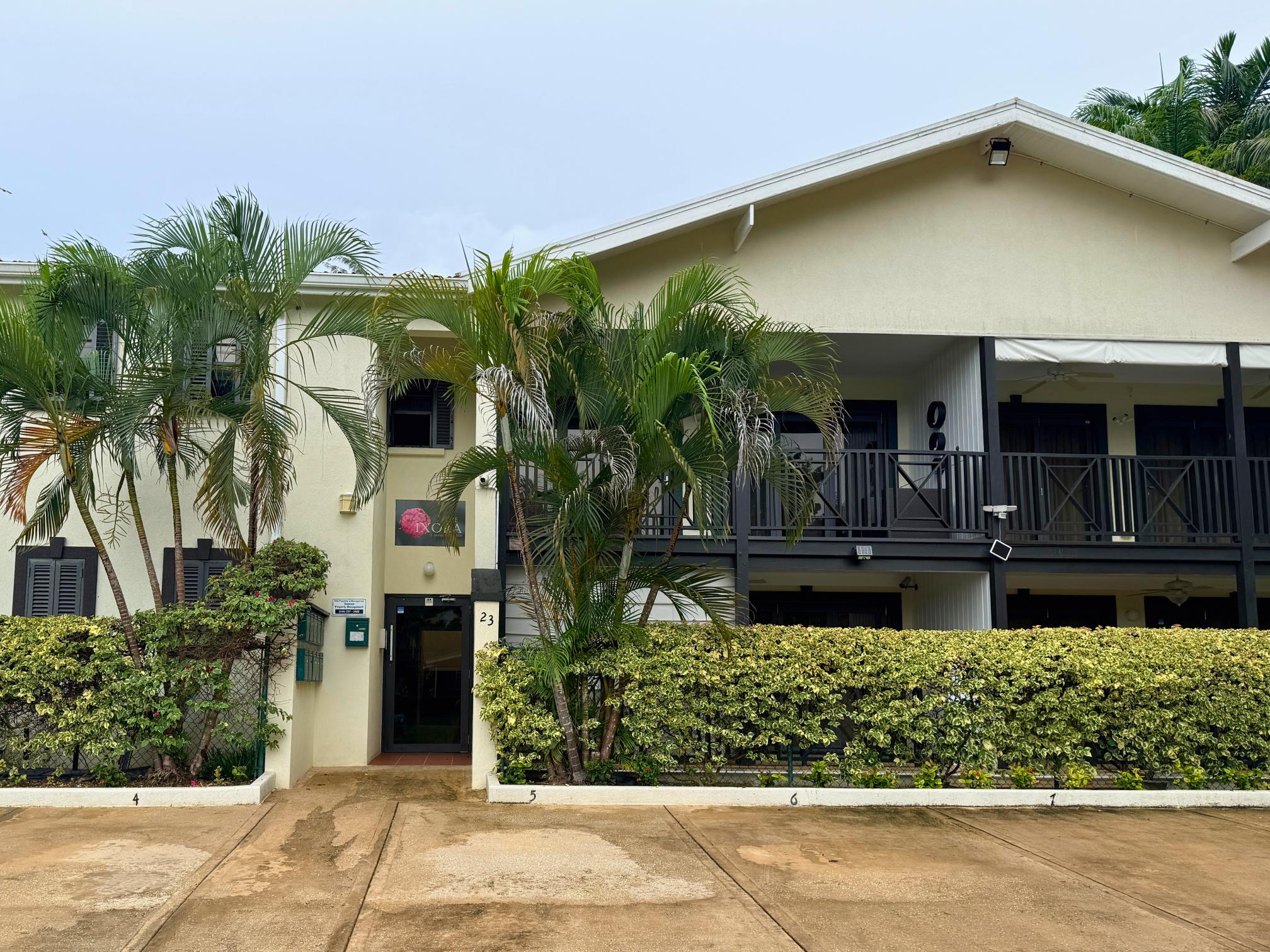 Tropical villa exterior with lush palms and spacious covered lanai