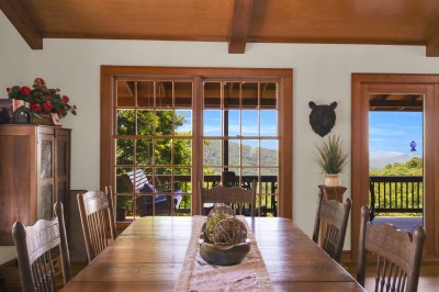 Gather for meals in this rustic dining room, featuring mountain views and easy deck access — the perfect spot to dine indoors or step outside for fresh air.