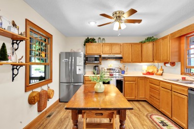 Bright farmhouse-style kitchen with island, stainless appliances, and warm wood charm