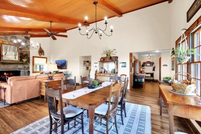 Gather in this rustic great room, featuring a warm fireplace, exposed beams, and a spacious dining area — the perfect space for cozy nights and shared mountain meals.