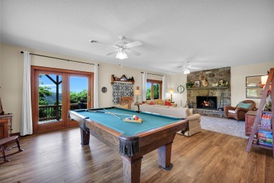 Gather around the pool table by a cozy stone fireplace, all set against scenic mountain views — a warm, inviting space made for friendly competition and relaxation.