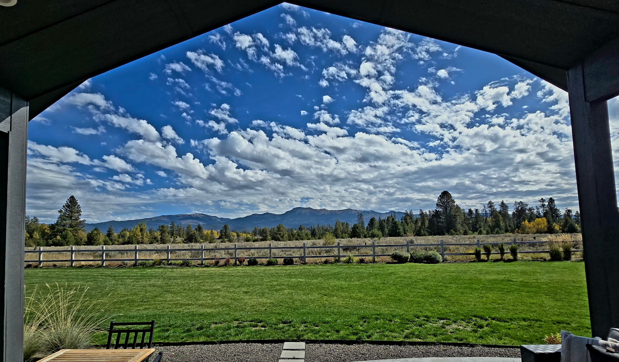 Covered patio with expansive lawn and stunning mountain views