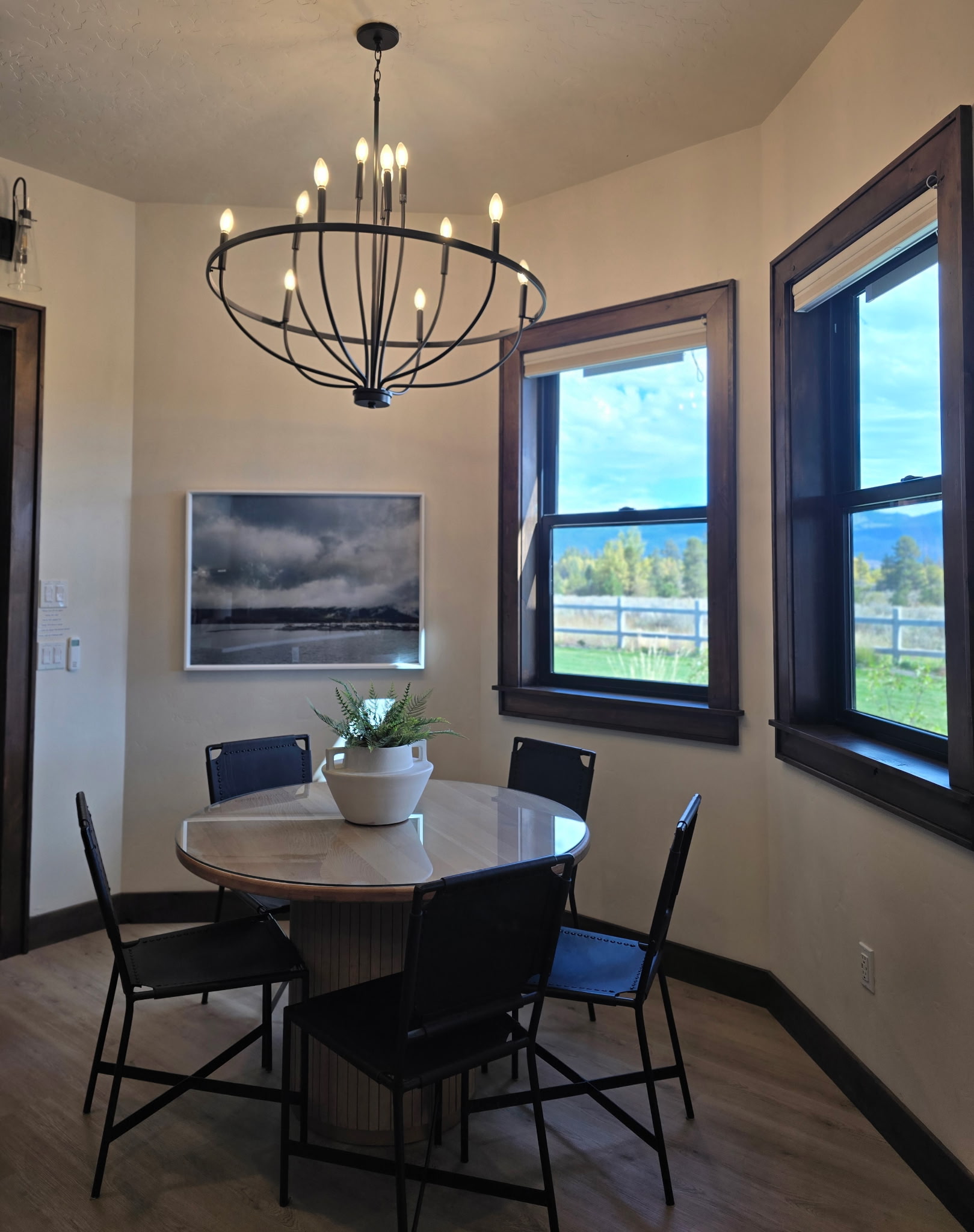 Sunny dining nook with stylish chandelier and scenic window views