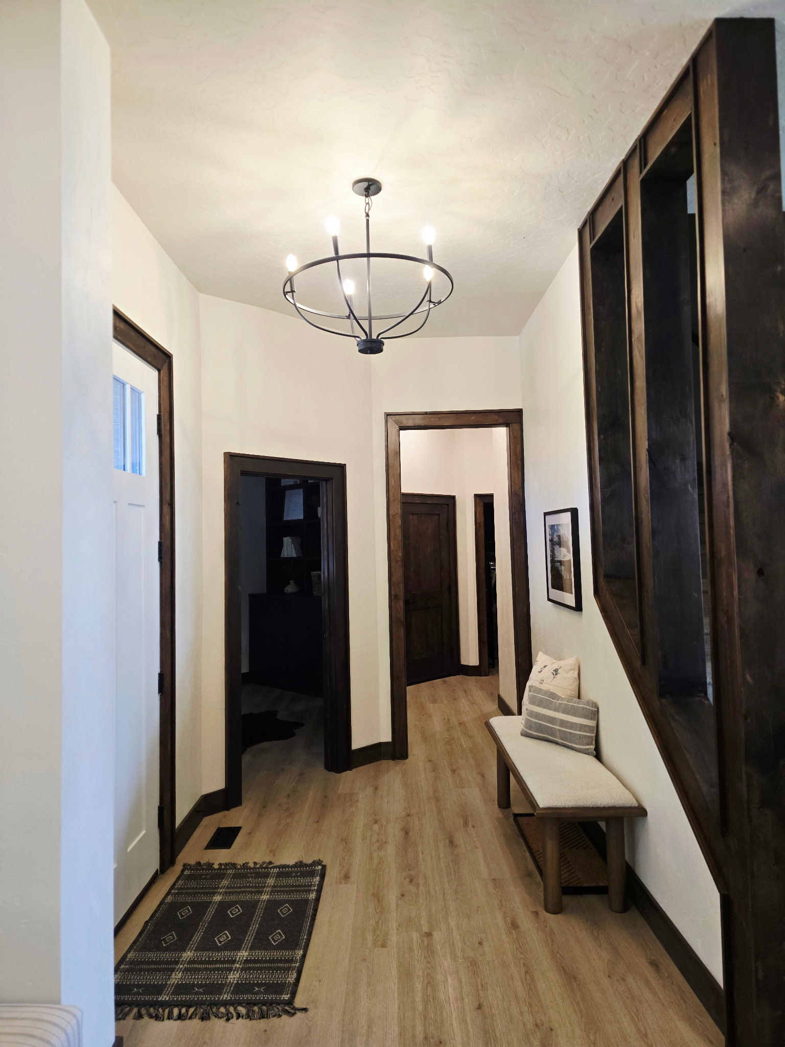 Bright entry hall with rustic wood accents and stylish chandelier