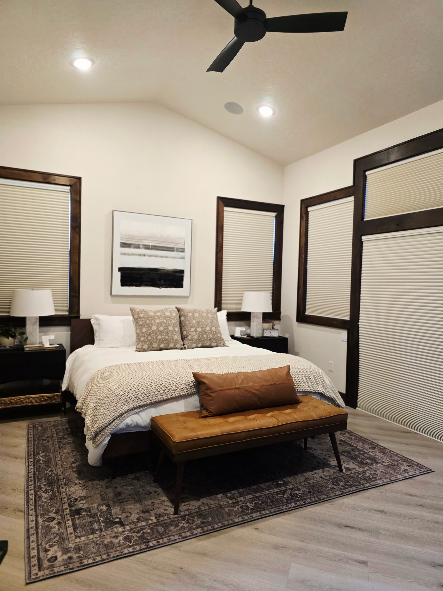Bright, vaulted bedroom with a plush bed and stylish modern-rustic touches