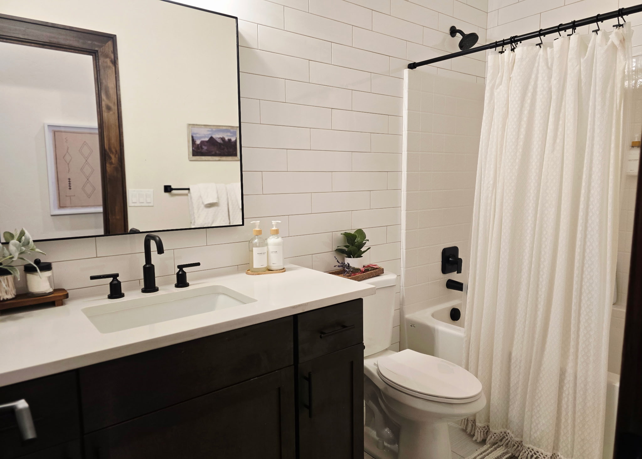 Modern bathroom with subway tile, black fixtures, and tub-shower combo