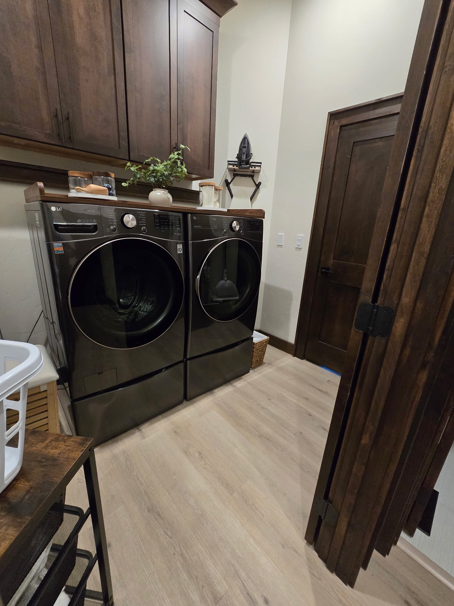 Upscale laundry room with front-load washer/dryer and ample storage