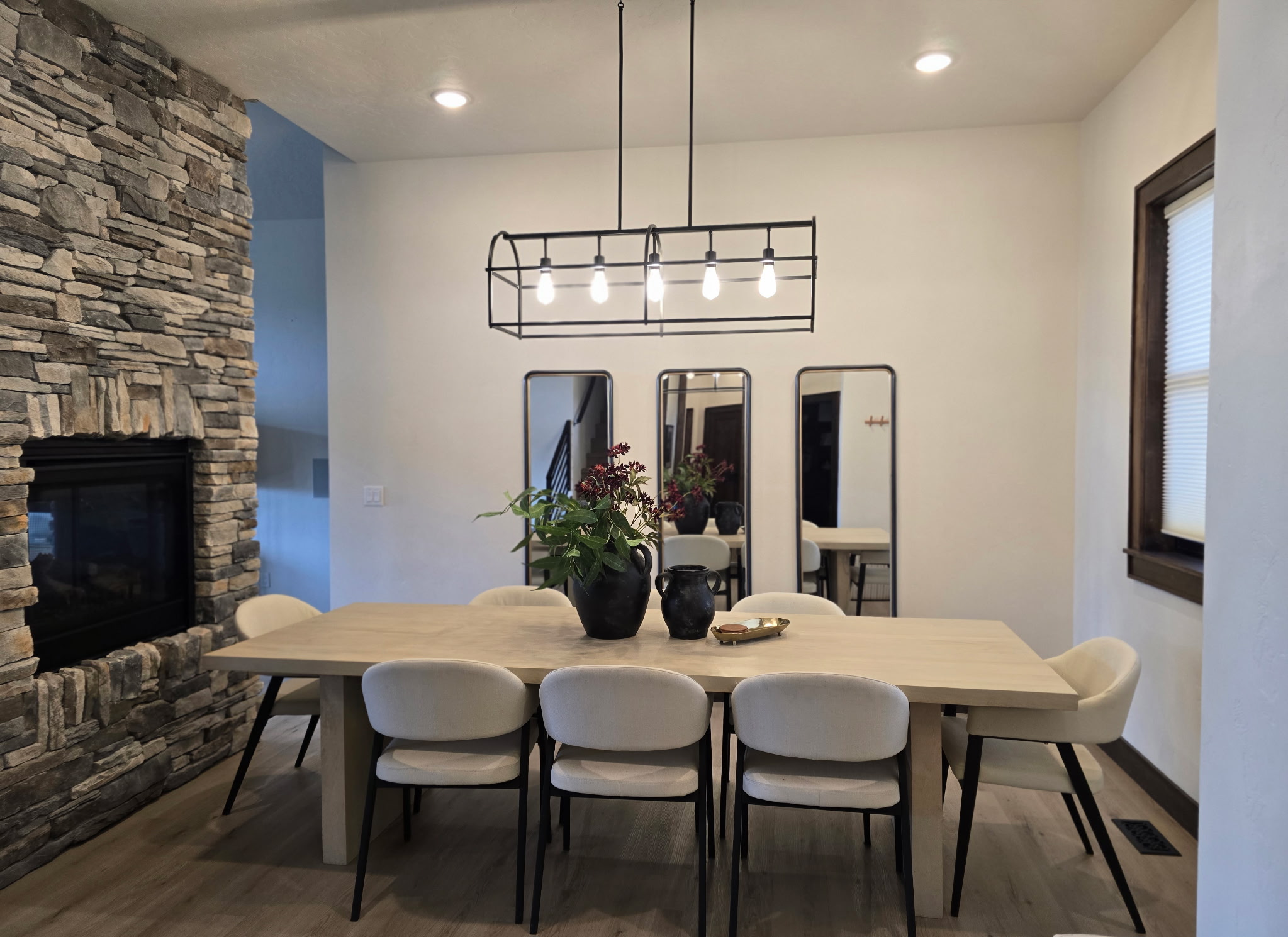 Modern dining room with stone fireplace and seating for six