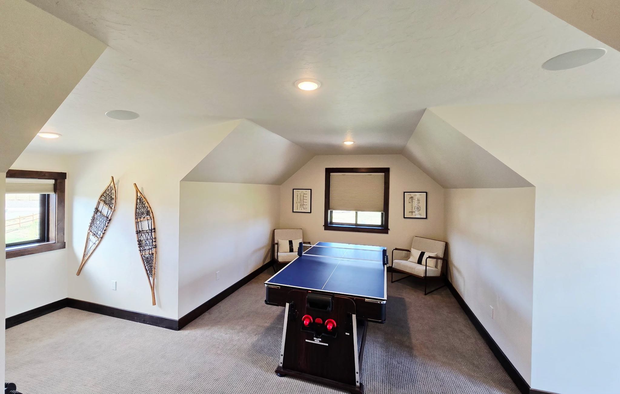 Cozy loft game room with ping pong table and charming cabin-style decor