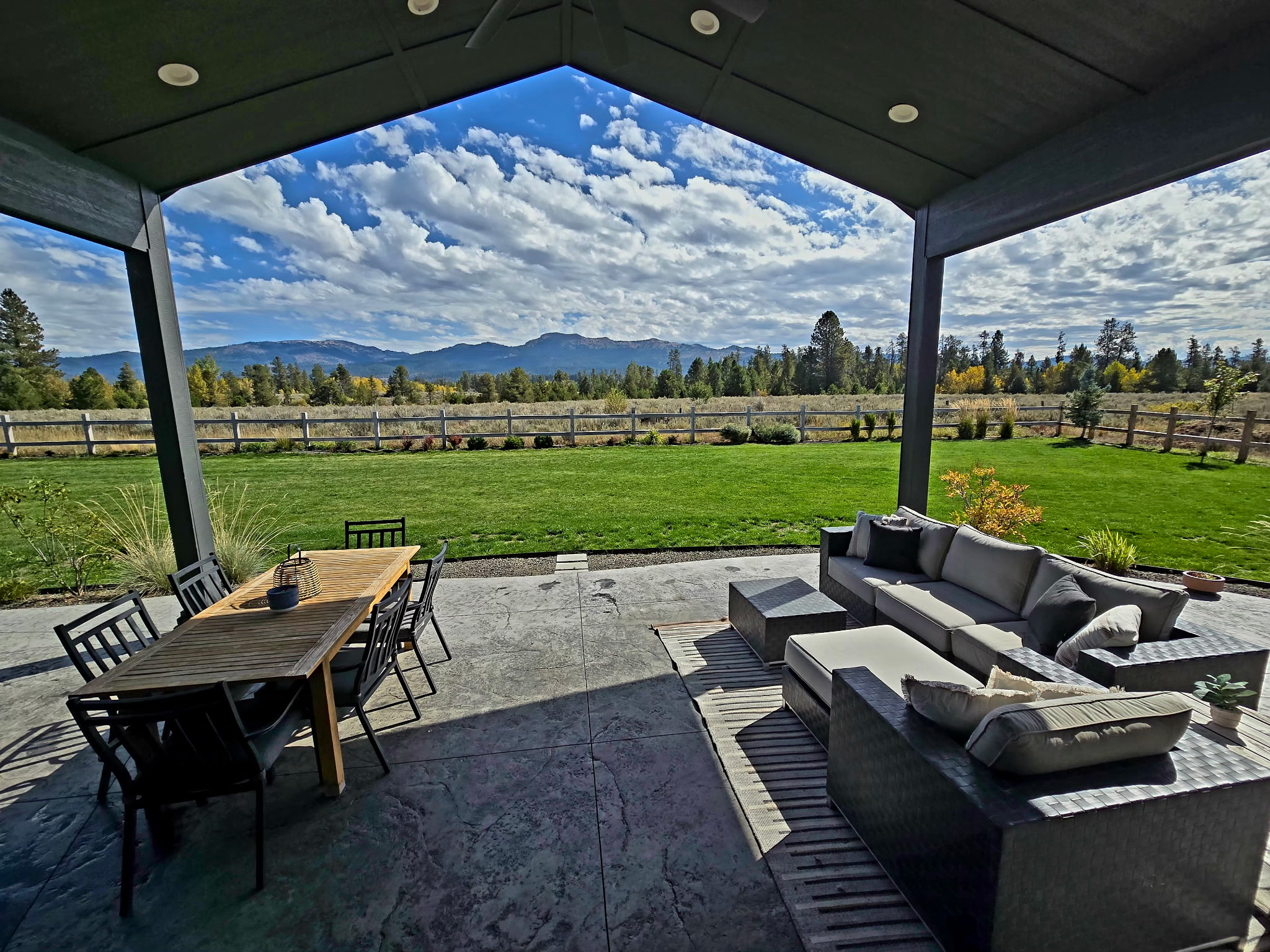 Covered patio with lounge seating, dining area, and stunning mountain views