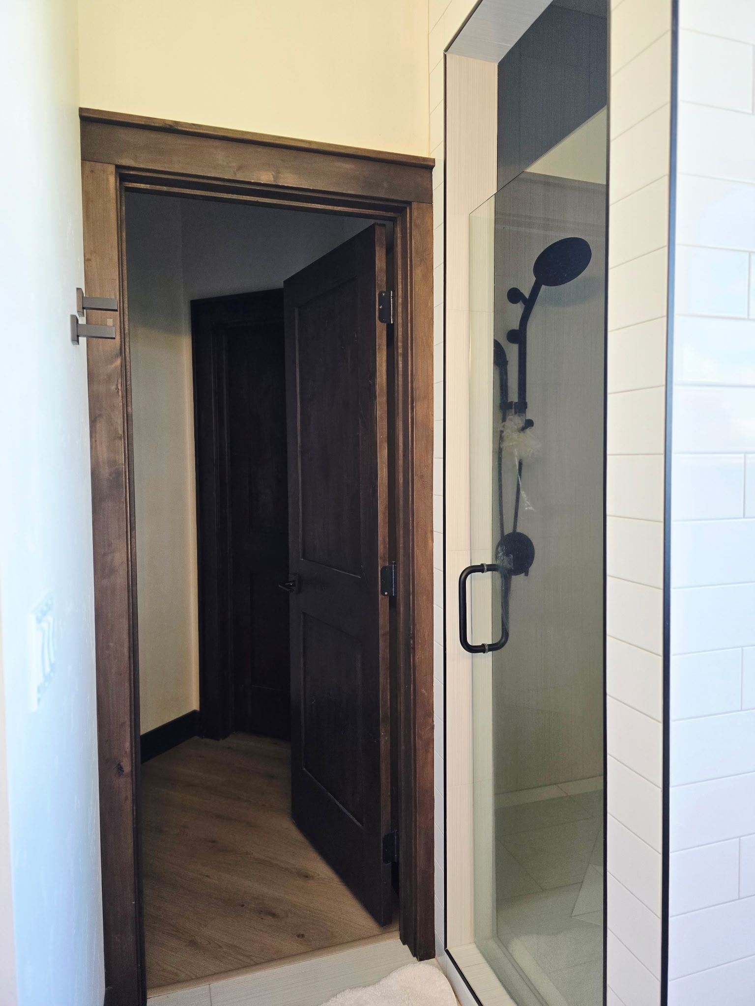 Modern walk-in shower with sleek glass door and warm wood accents