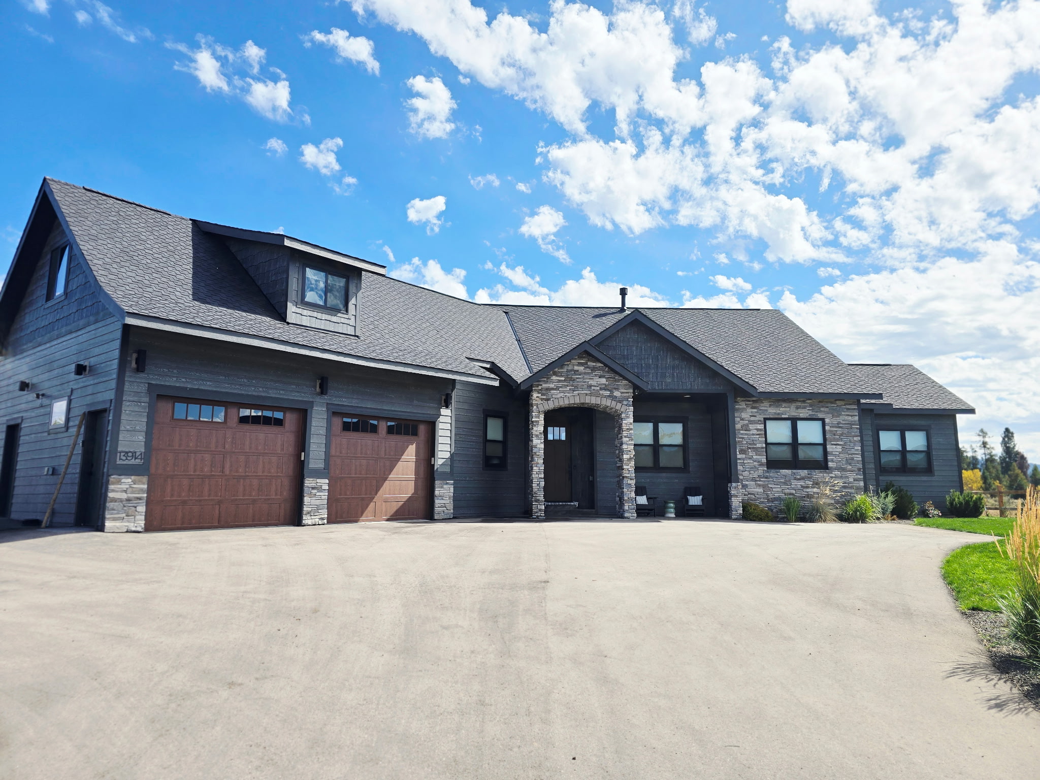 Striking modern home with stone accents and spacious driveway